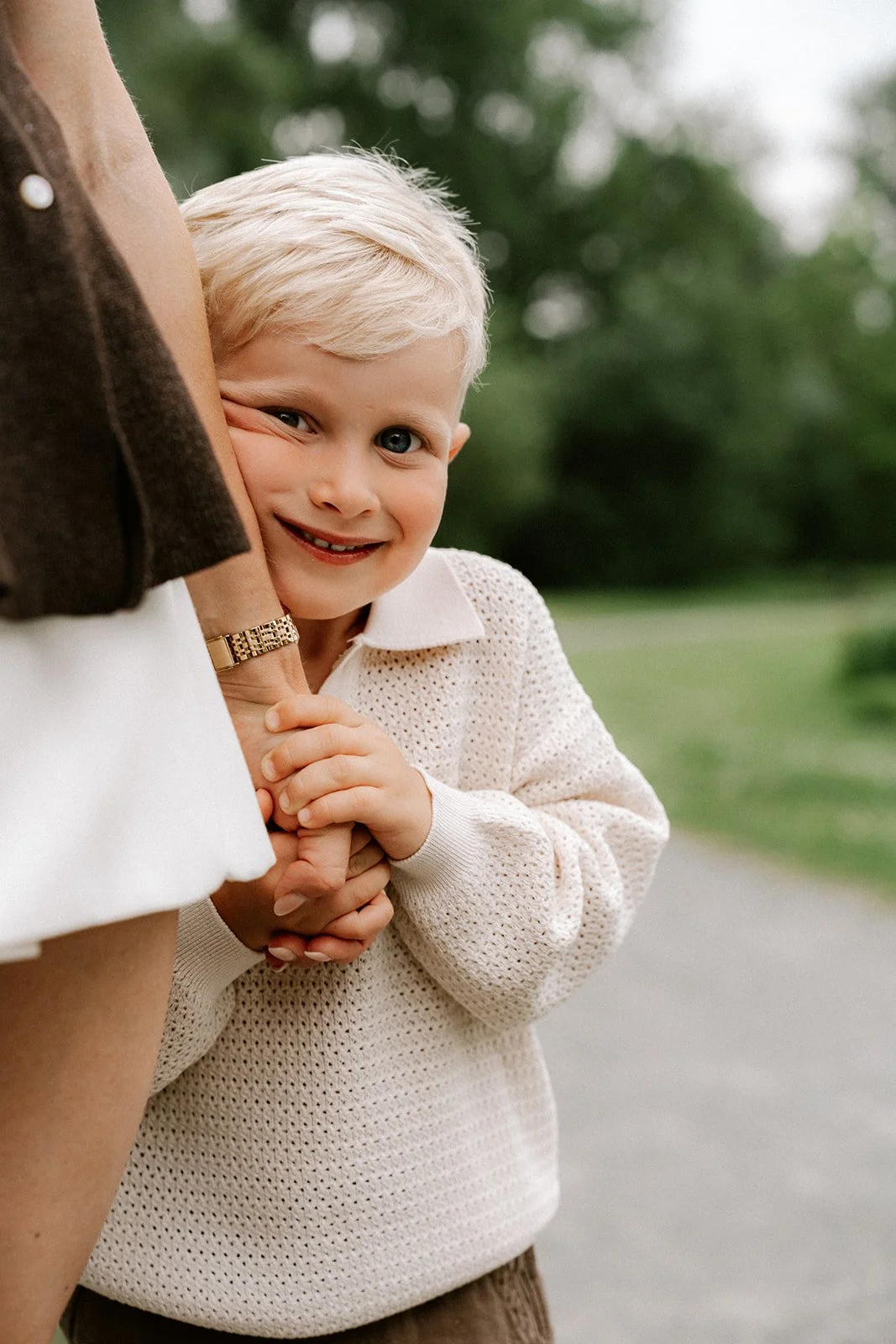 Detailfoto van liefdevolle interactie tussen moeder en zoon tijdens een familieshoot.