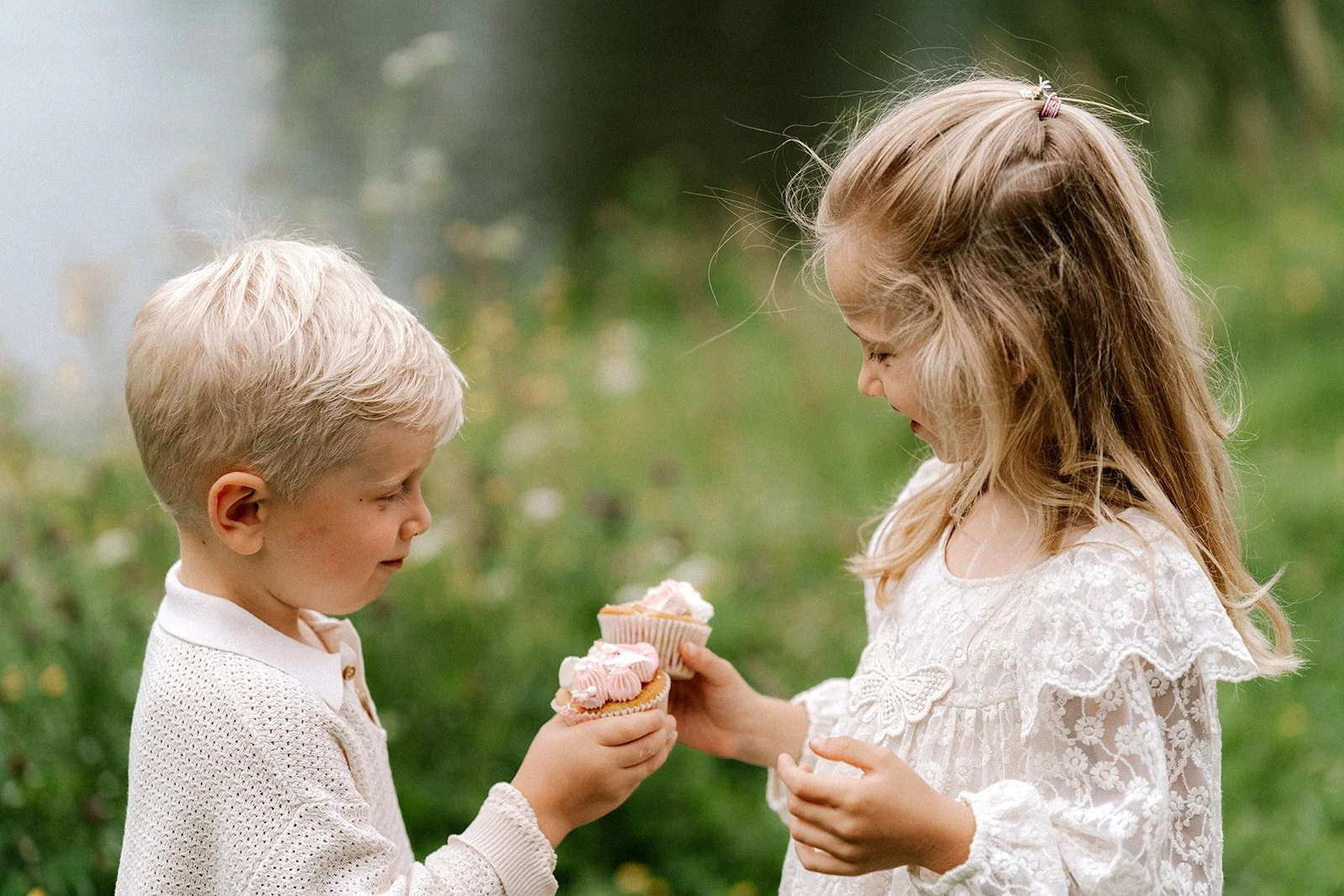 broer en zus houden een cupcake vast tijdens een familie fotoshoot in de natuur