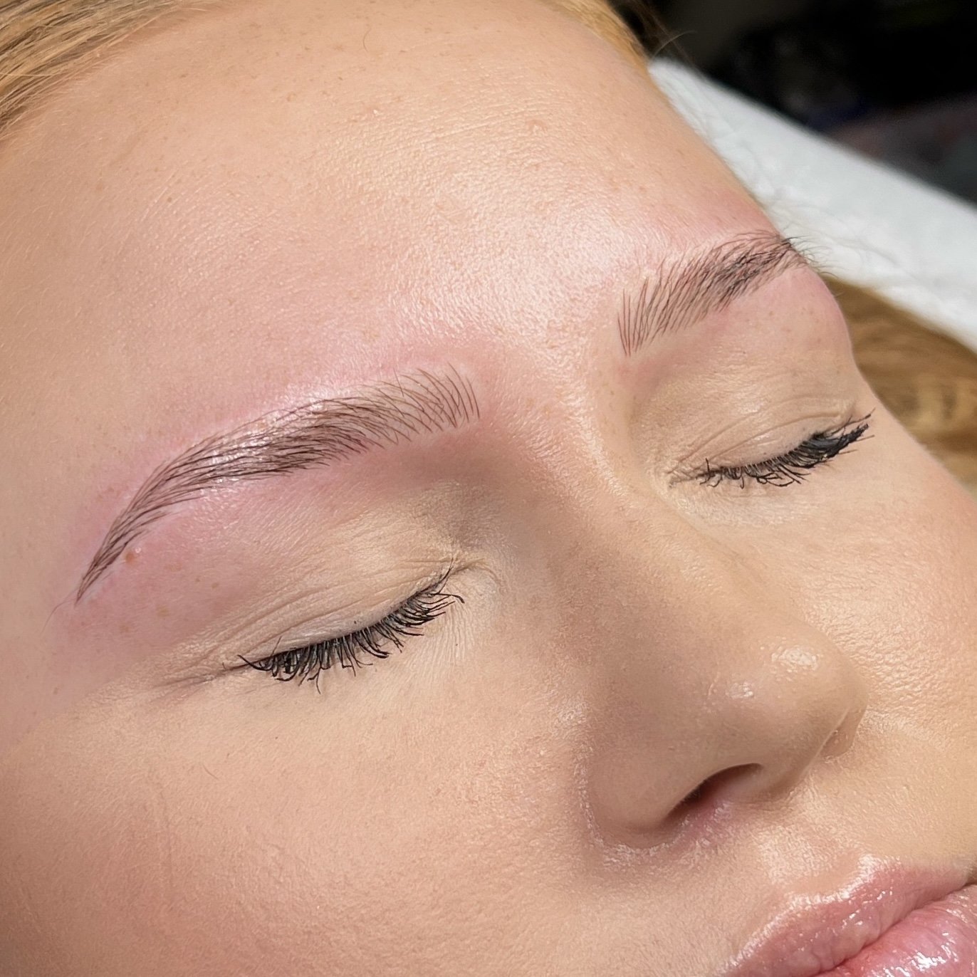 Lähikuvassa naisen kasvot, joihin on juuri tehty microblading tai puuterikulmat käsittely.