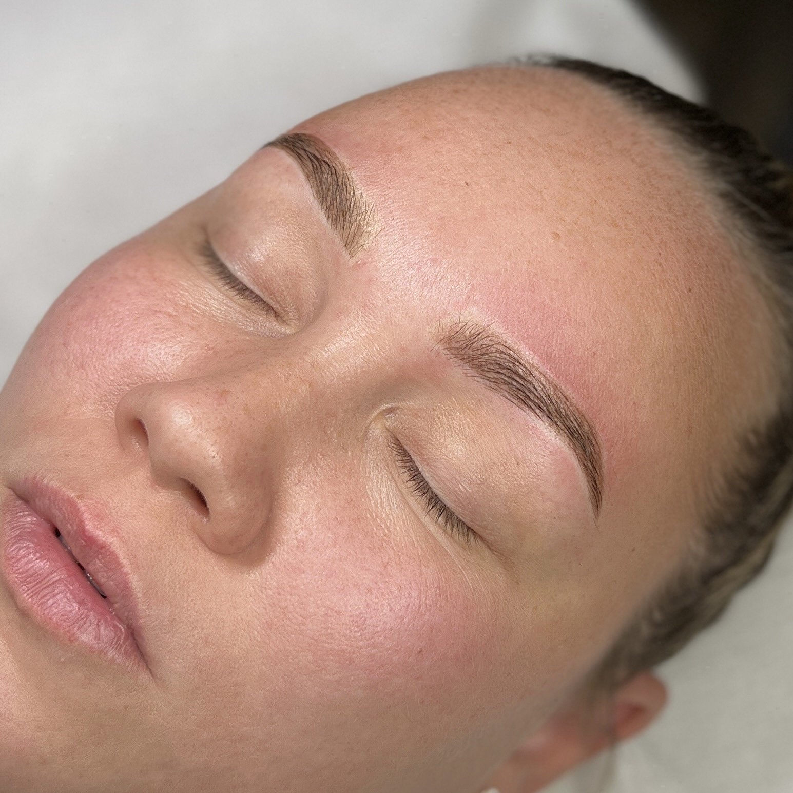 Lähikuvassa naisen kasvot, joihin on juuri tehty microblading tai puuterikulmat käsittely.