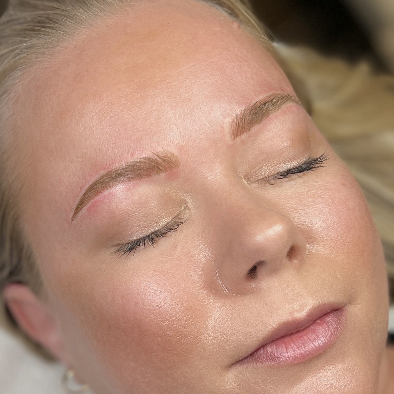 Lähikuvassa naisen kasvot, joihin on juuri tehty microblading tai puuterikulmat käsittely.