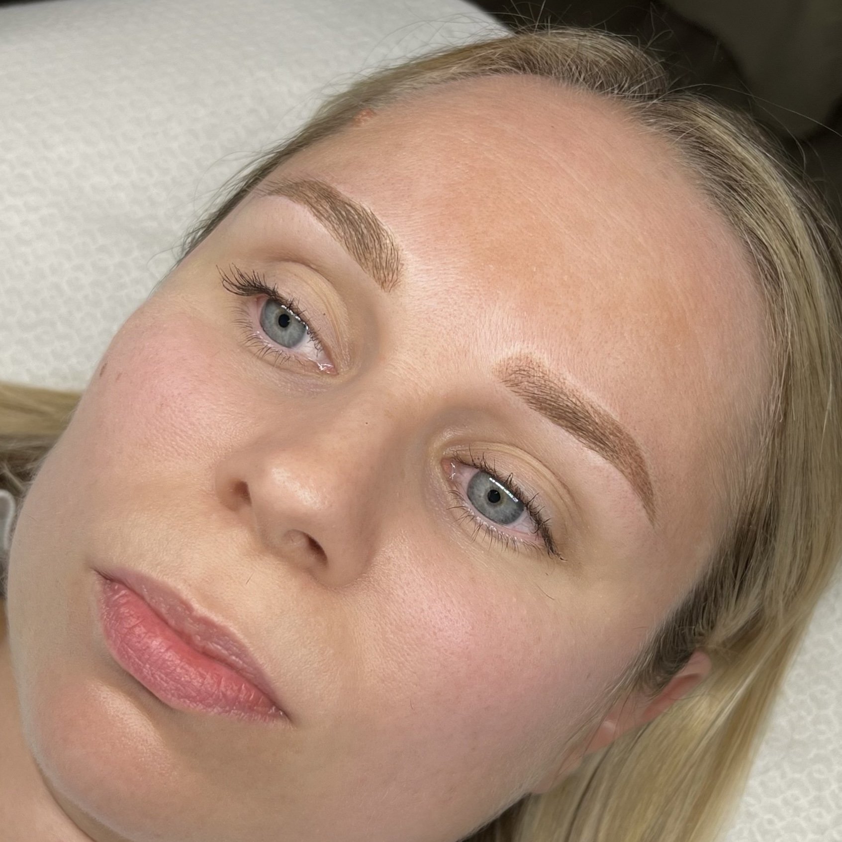 Lähikuvassa naisen kasvot, joihin on juuri tehty microblading tai puuterikulmat käsittely.