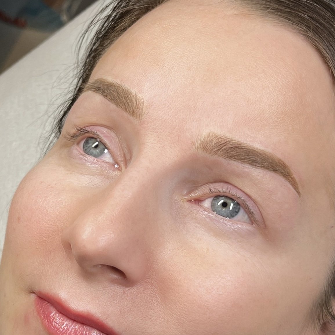 Lähikuvassa naisen kasvot, joihin on juuri tehty microblading tai puuterikulmat käsittely.