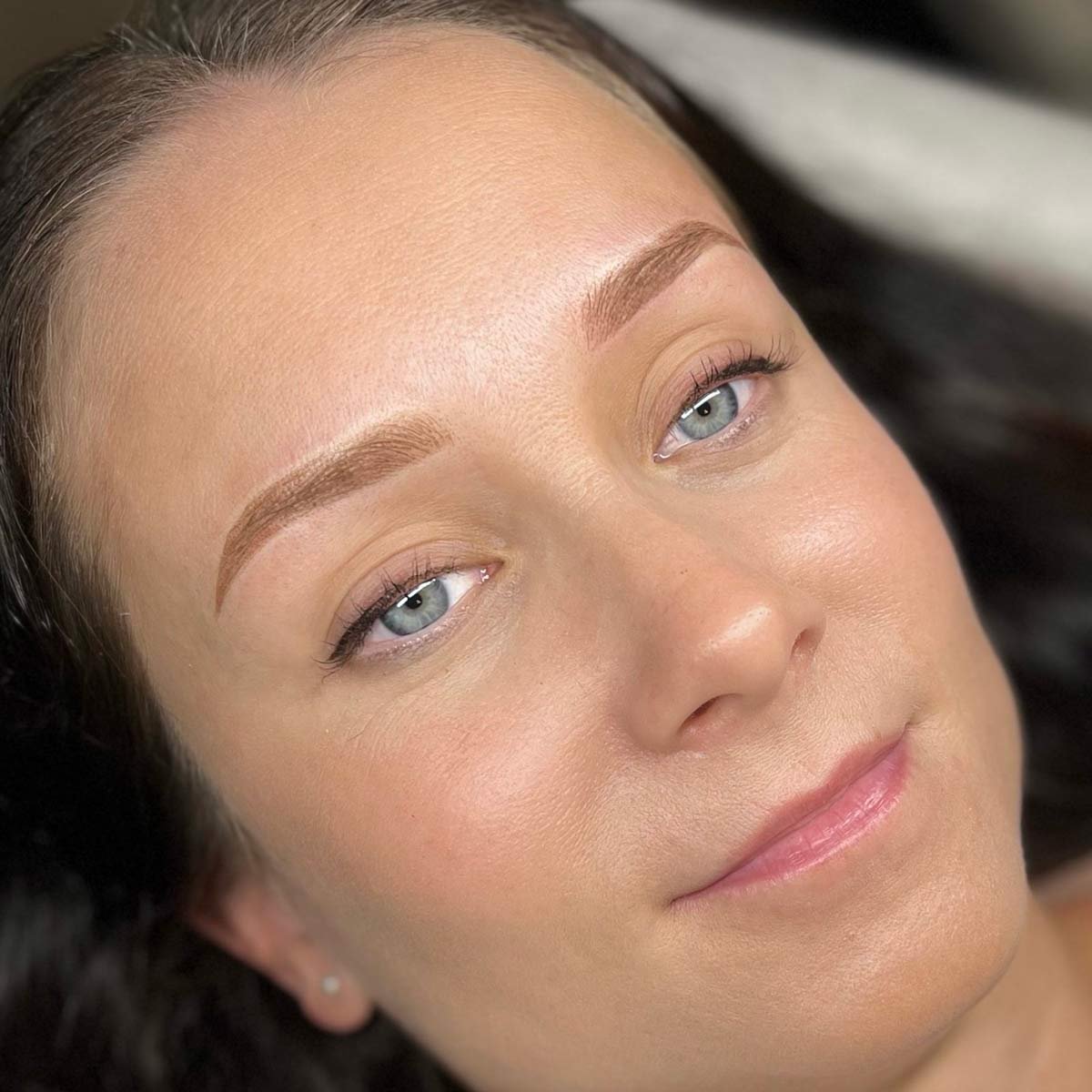 Lähikuvassa naisen kasvot, joihin on juuri tehty microblading tai puuterikulmat käsittely.