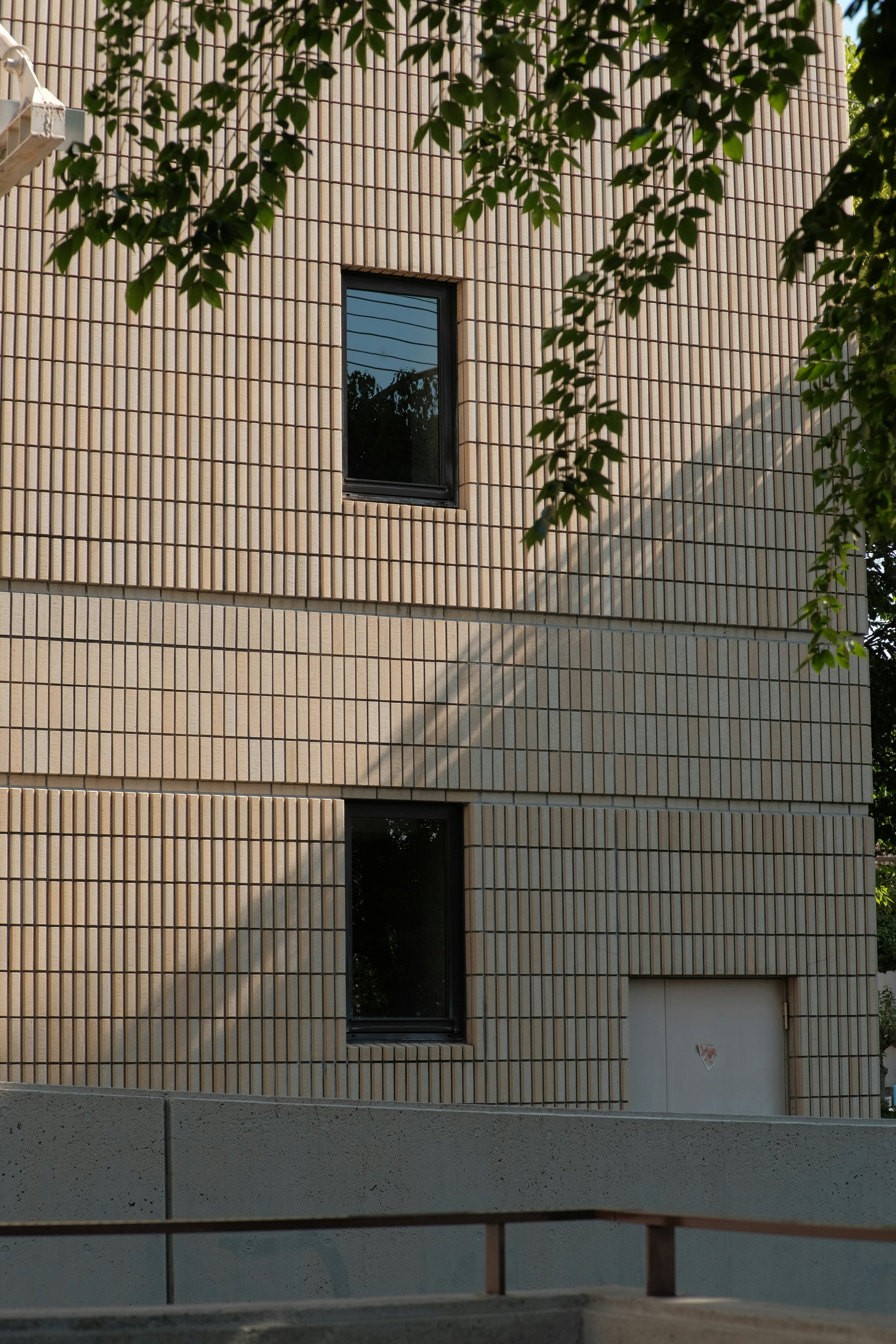 Fachada de un edificio de ladrillos con dos ventanas.