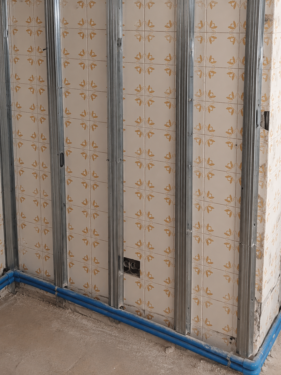 Perfilería metálica para tabiquería de placa de yeso laminado con instalaciones vistas durante una reforma.