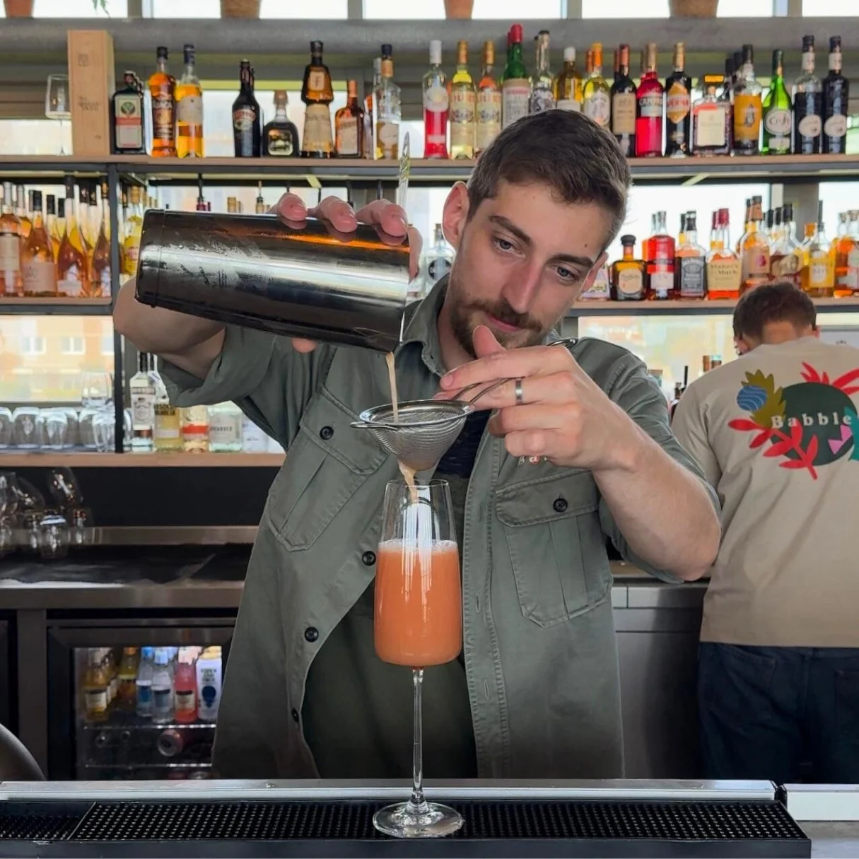 A bartender pouring a cocktail at Babble
