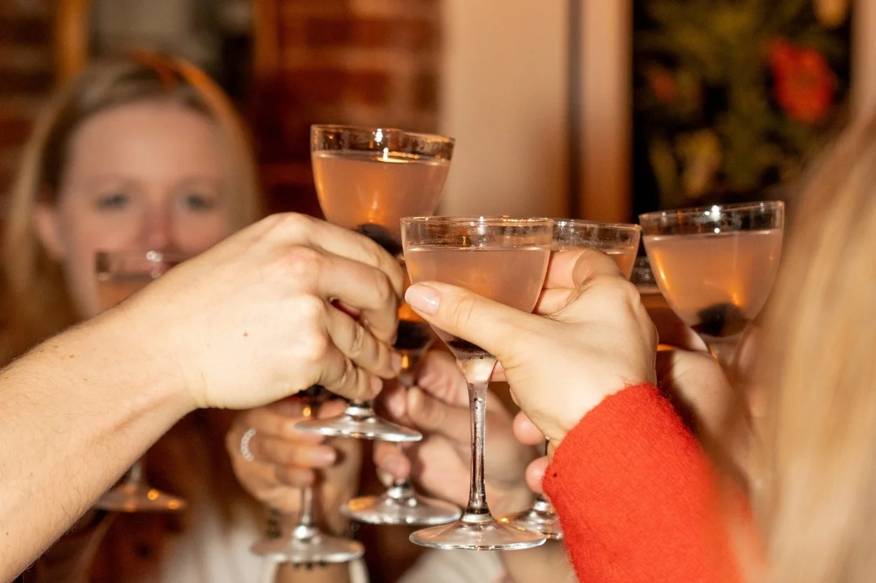 A group of friends raising a toast with a Brighton Cocktail Festival cocktail