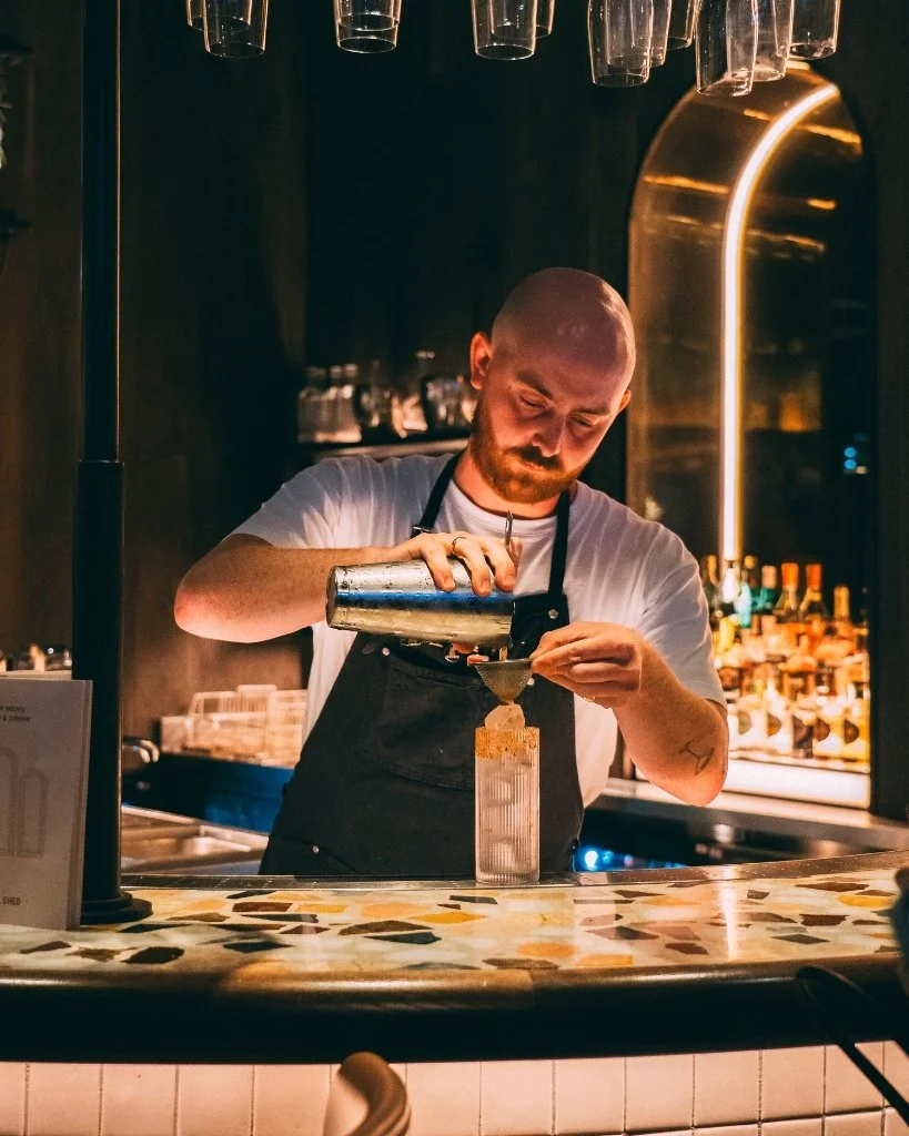 A bartender at The Coal Shed pouring a cocktail for Brighton Cocktail Festival.