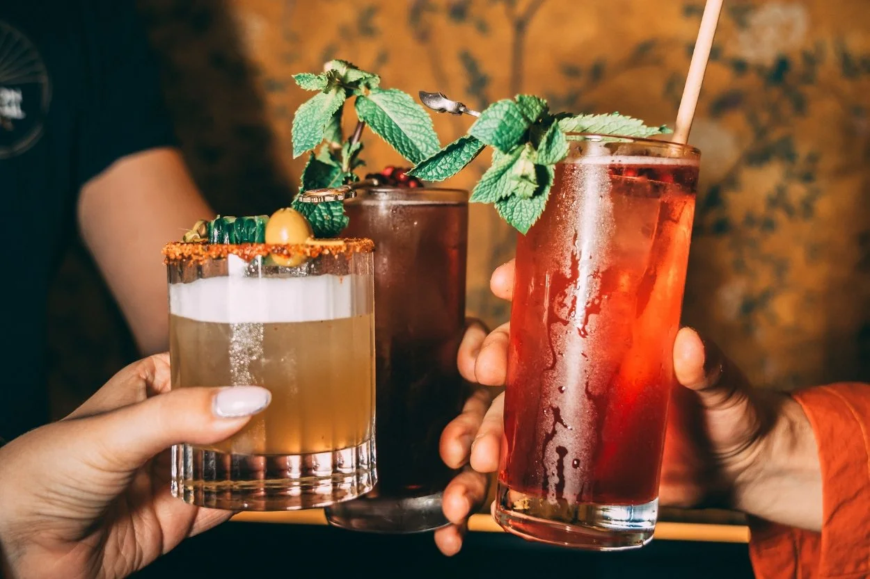 Three cocktails raised together to cheers.