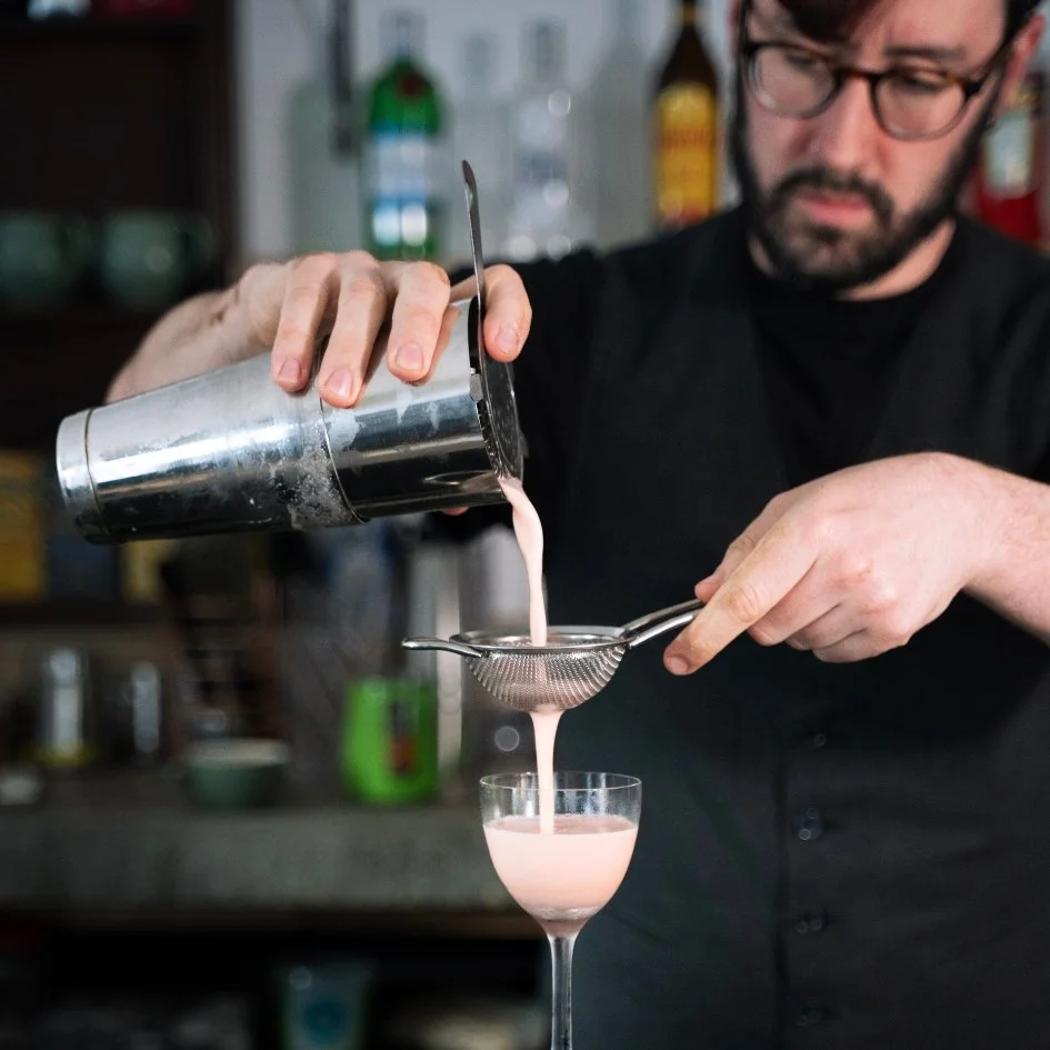 A bartender pouring a cocktail at The Archives