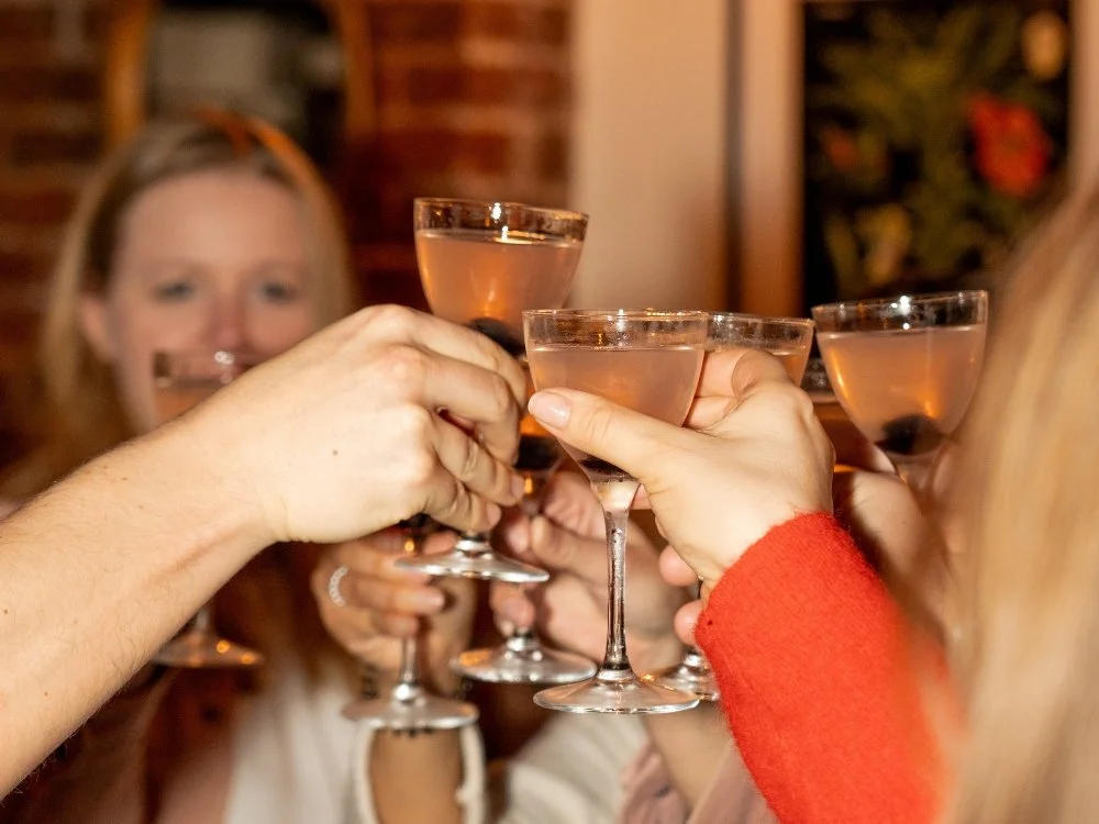 A group of friends raising a toast with a Brighton Cocktail Festival cocktail