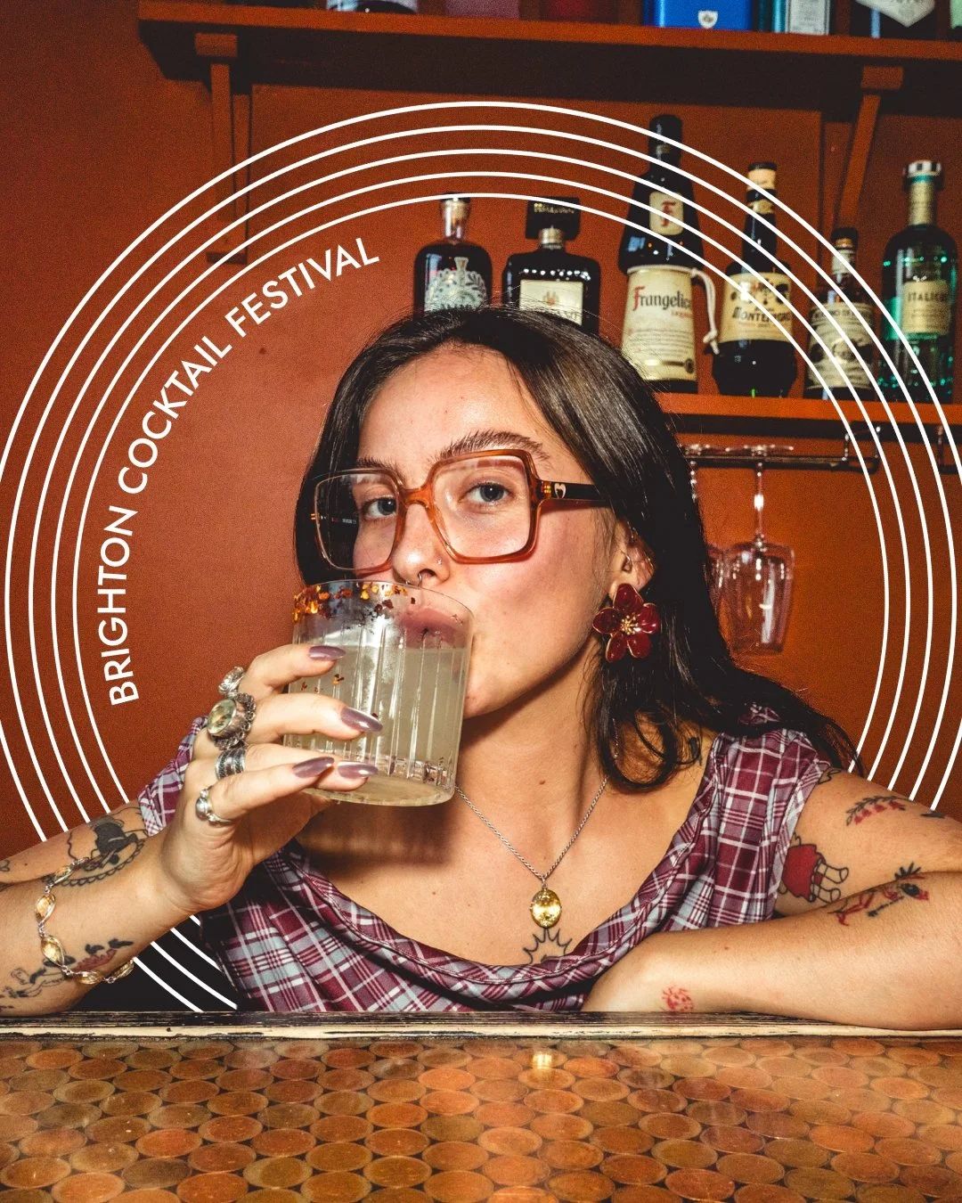 A bartender drinking a cocktail with the words Brighton Cocktail Festival in a circle around her.