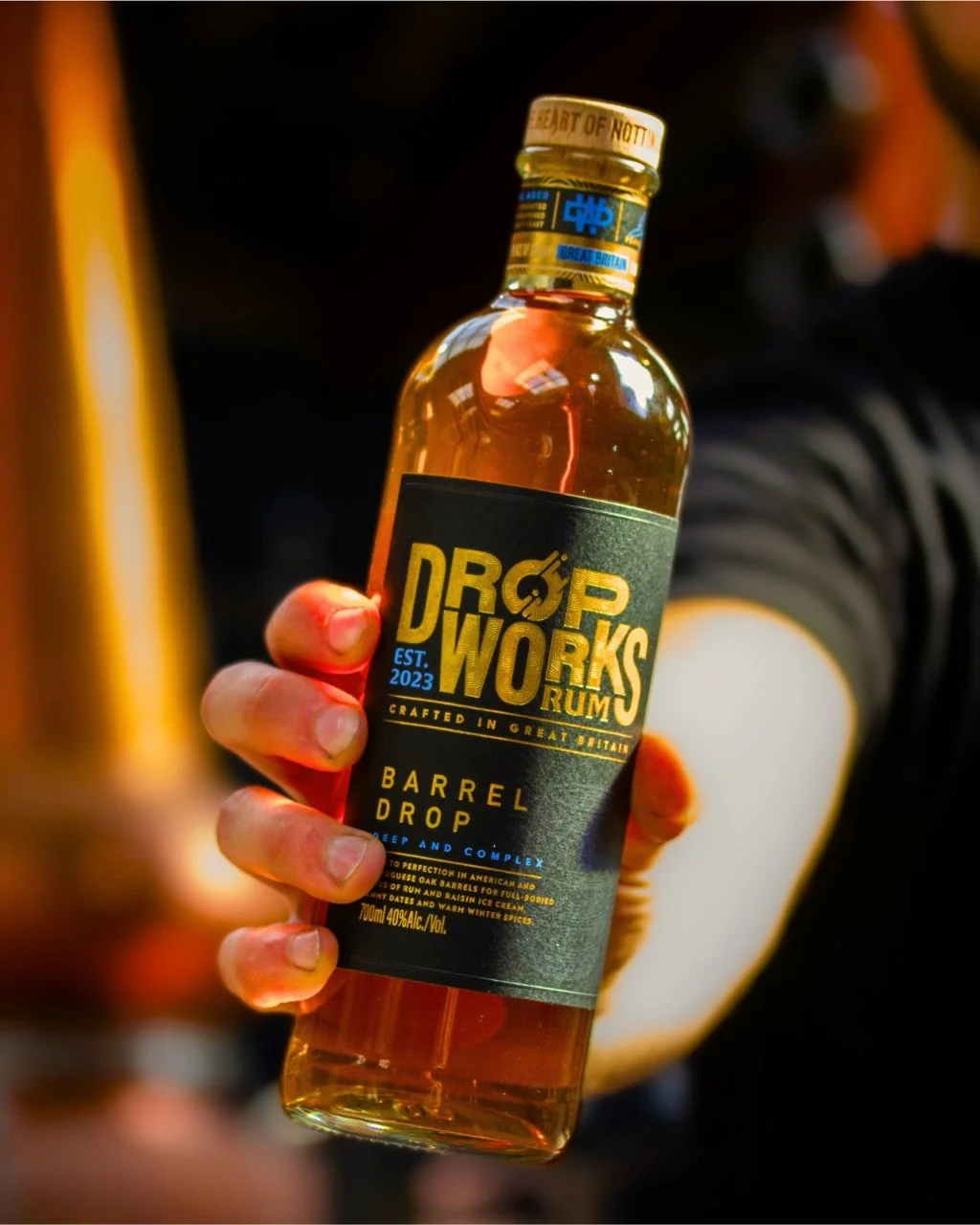 A bottle of DropWorks Rum being held to camera.