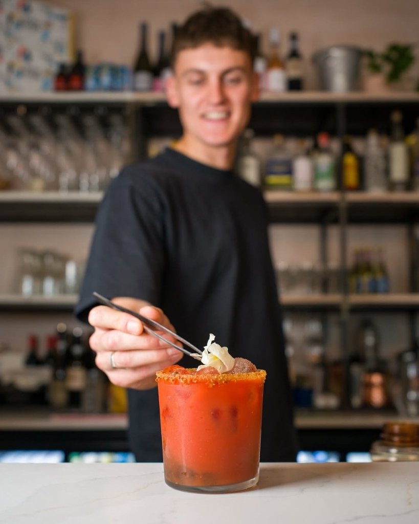 A bartender garnishing a cocktail at The Canopy in Brighton.