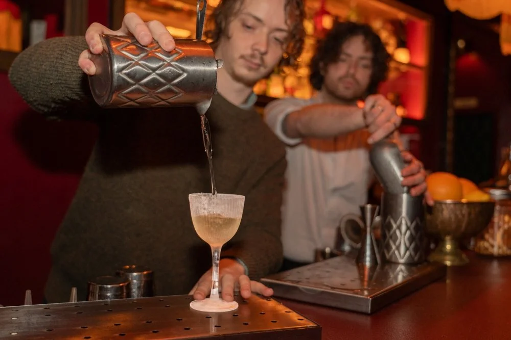 Two bartenders creating cocktails