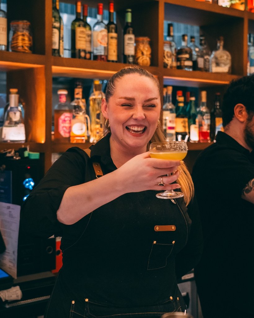A bartender at Tutto raising a glass for Brighton Cocktail Festival.