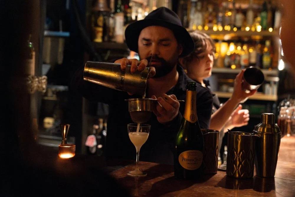 A bartender pouring a cocktail