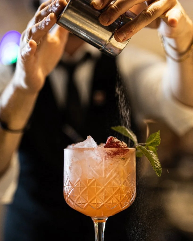 A bartender garnishing a cocktail at HarBAR.