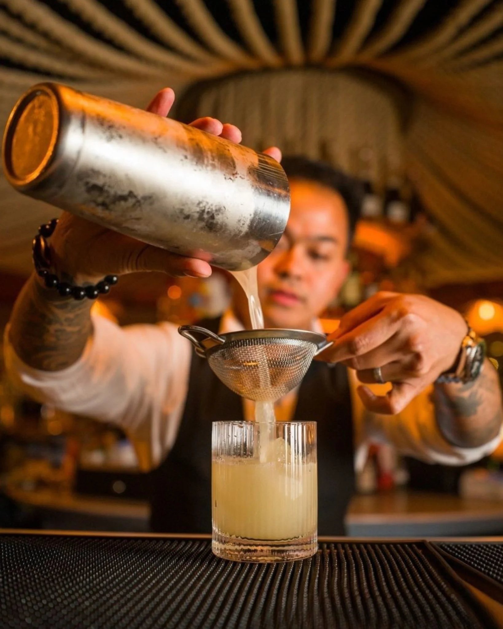 A bartender at Drift pouring a cocktail.