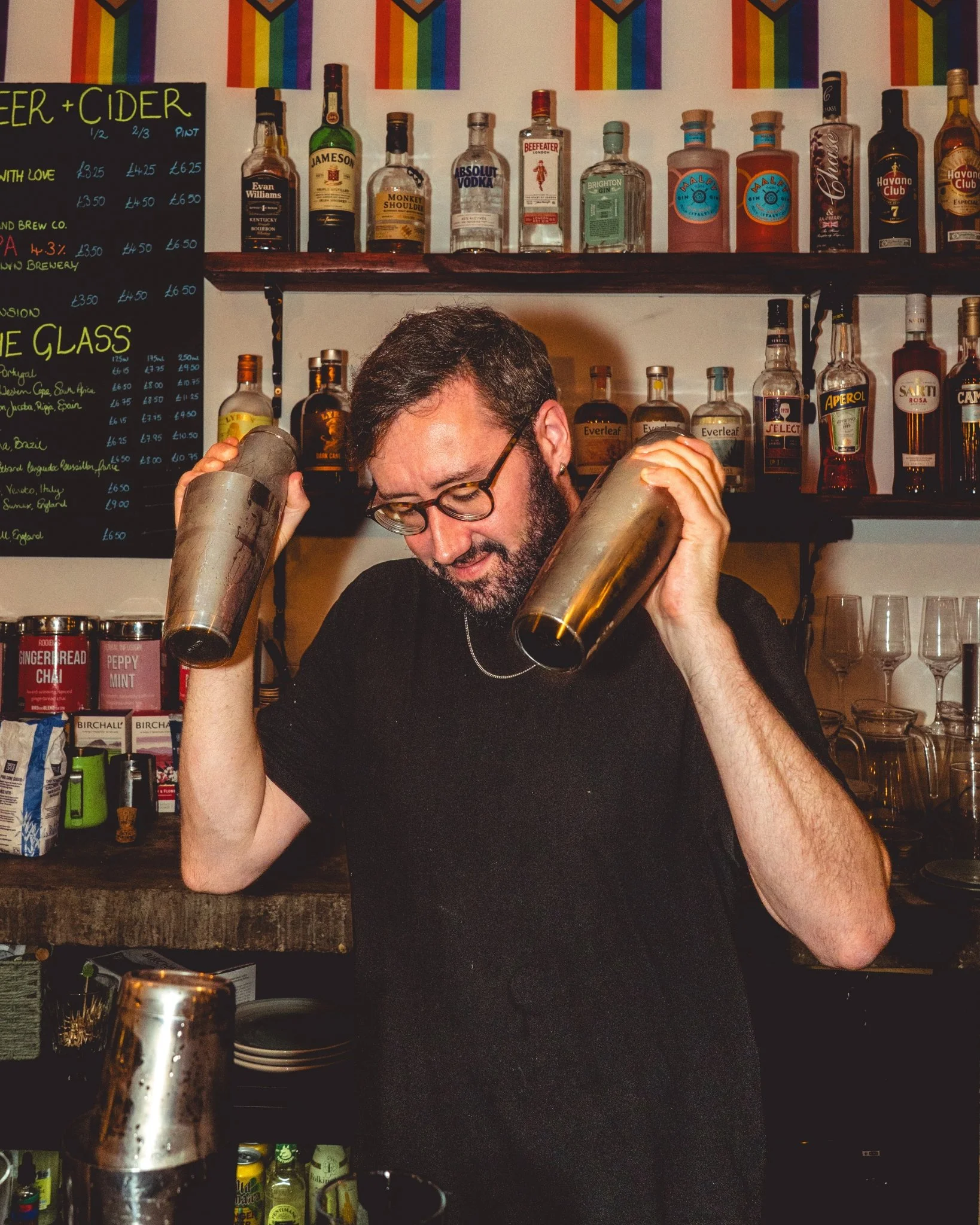 A bartender at The Archives shaking two cocktail shakers at once.