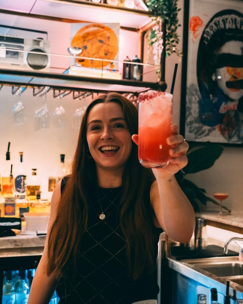 A bartender raising a Brighton Cocktail Festival cocktail at Helm Gallery.