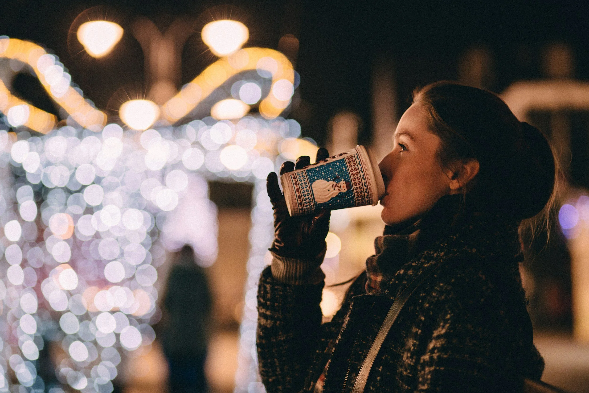 woman drinking coffee outside at christmas