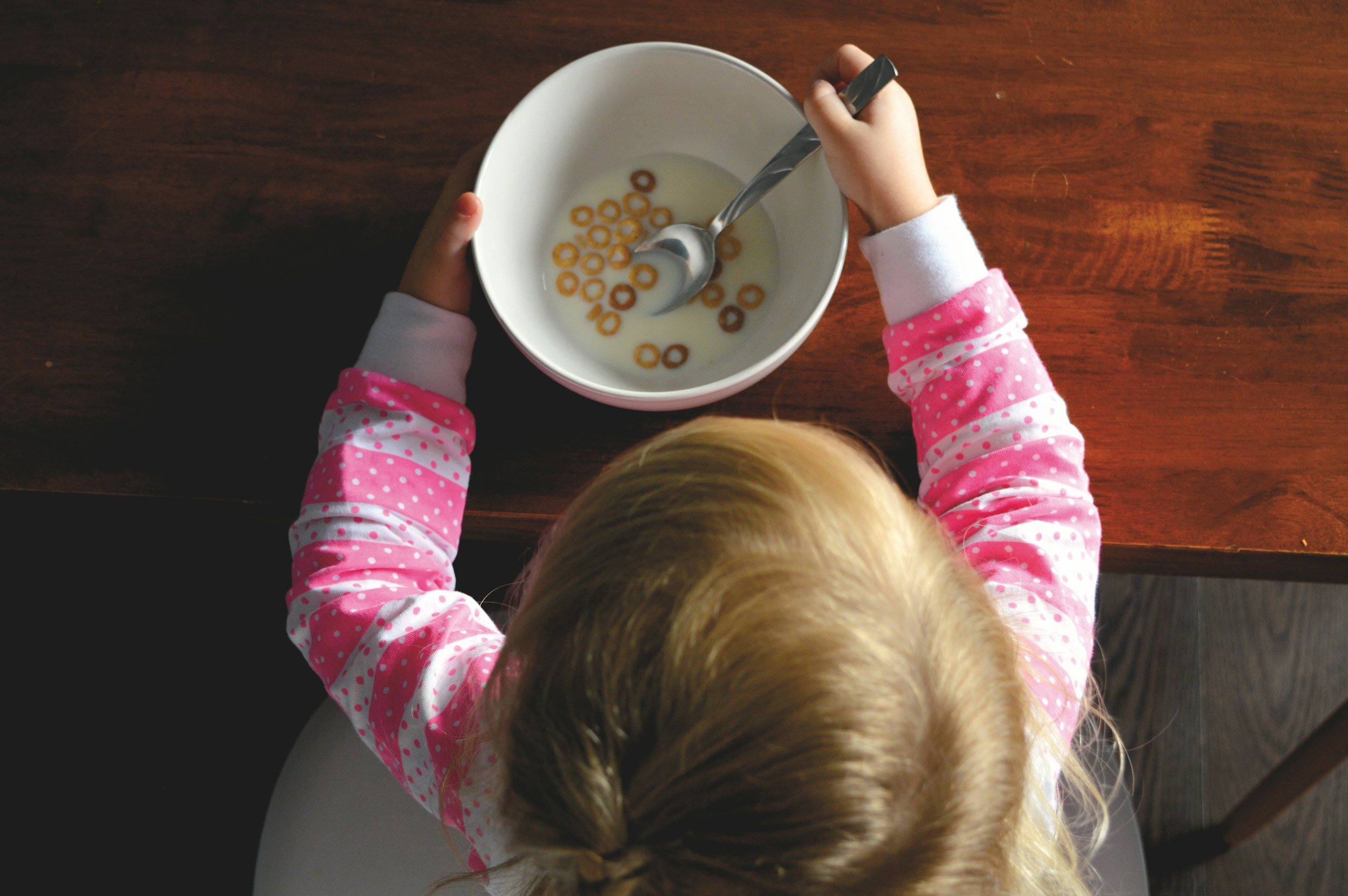 Kind verweigert beim Fruehstueck das Essen und sitzt am Familientisch
