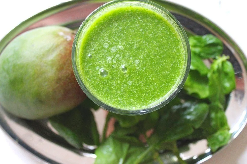 Glas mit gesundem gruenen Smoothie fuer Kinder