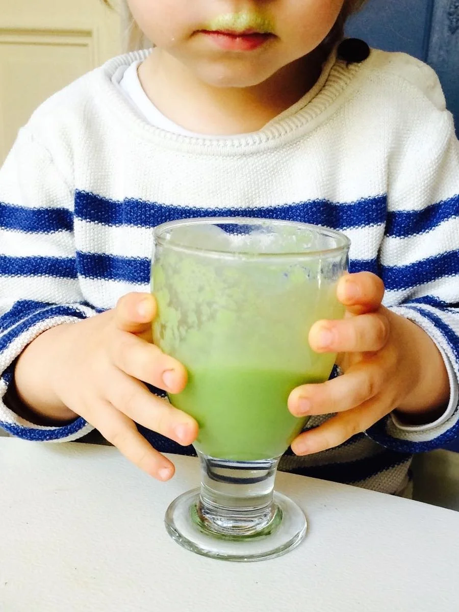 Kleinkind trinkt gruenen Smoothie gesunde Ernaehrung