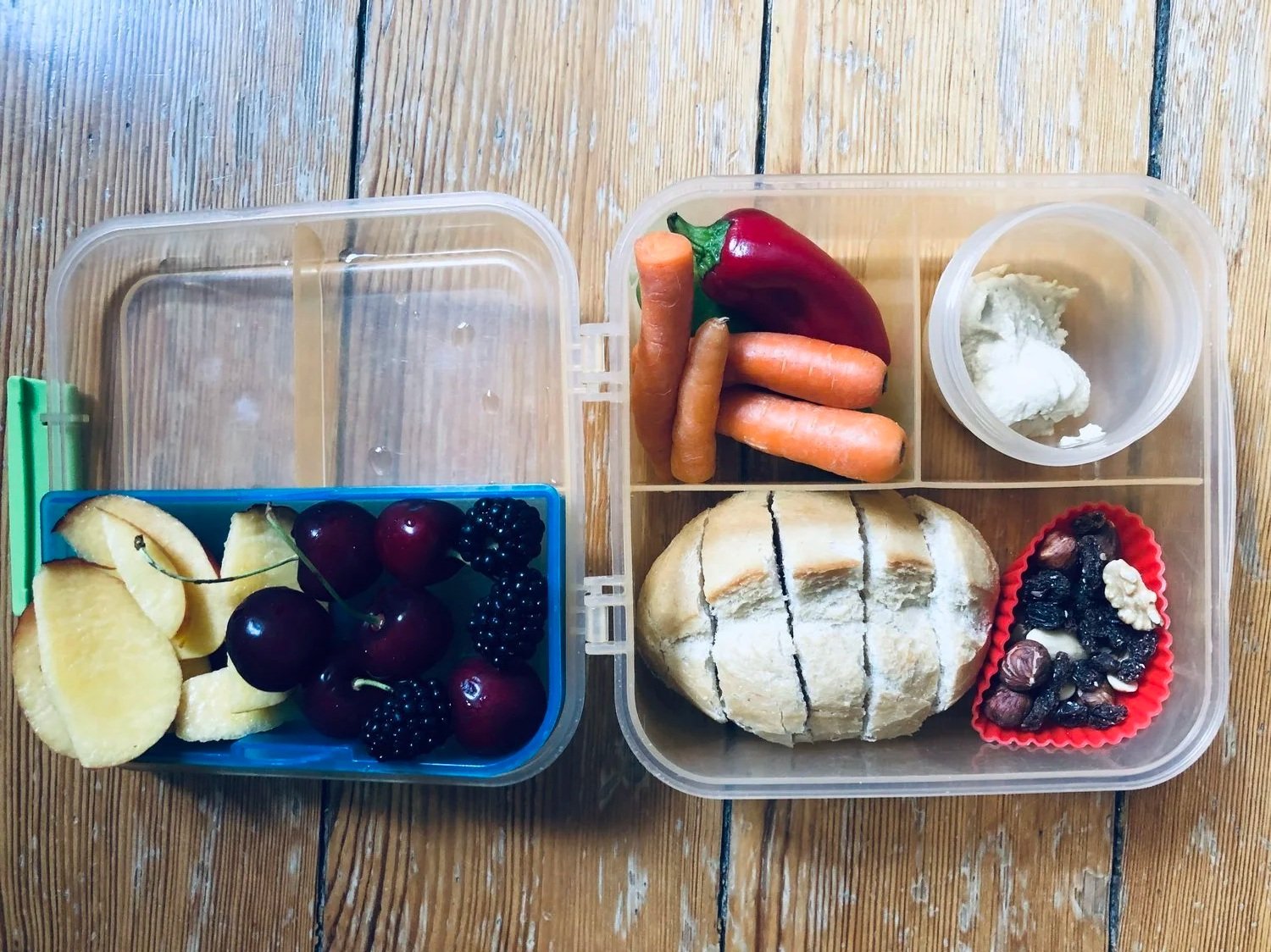 Volle Brotdose für ein Schulkind mit Brot, Obst und Gemüse