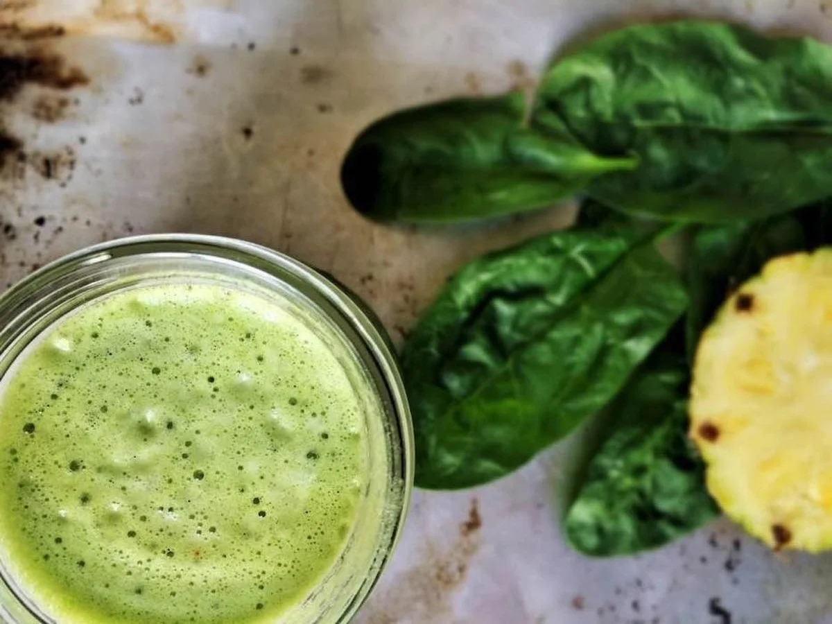 Glas mit grünem Smoothie auf einem Tisch