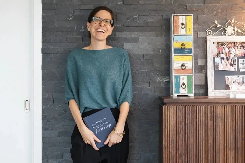 Zeigt Yvonne Durand, Karriere- und Leadership Coach für erfahrene Fach- und Führungskräfte lachend mit einem Journal in der Hand