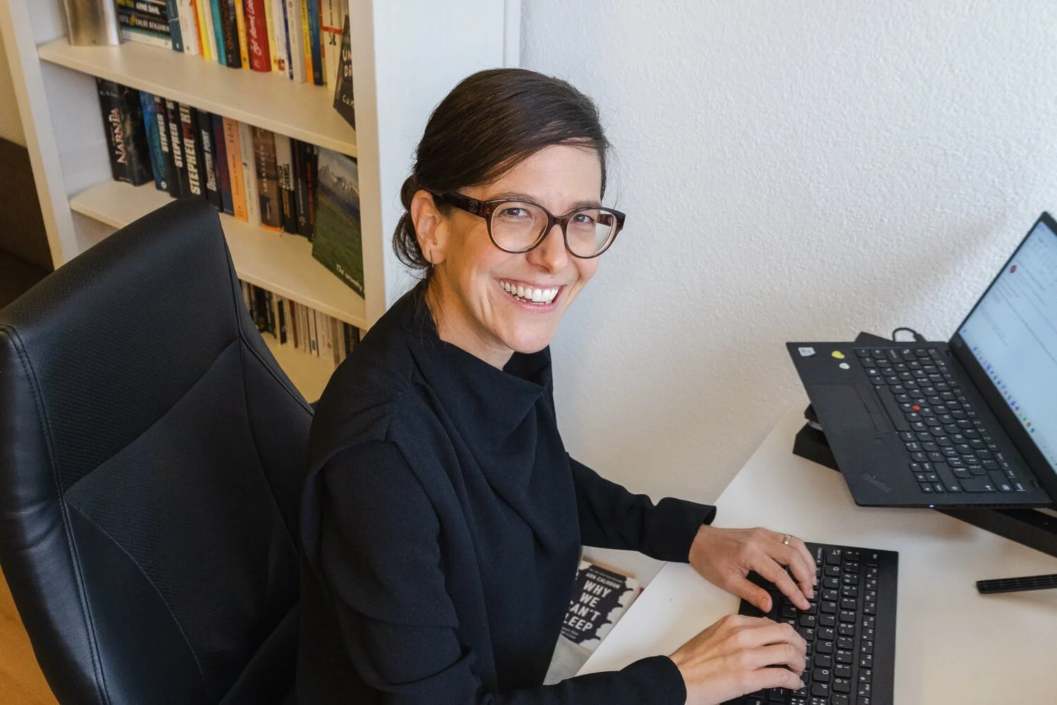 Yvonne smiling while typing at her desk