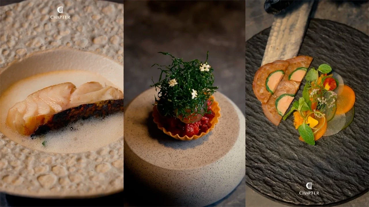 Three images of gourmet dishes: first features a cooked fish fillet on foam with foam and a slice of crispy skin; second shows a small tart filled with red sauce, topped with greens and flowers on a speckled beige surface; third displays a black slate plate with sliced meats, vegetables, and edible flowers.
