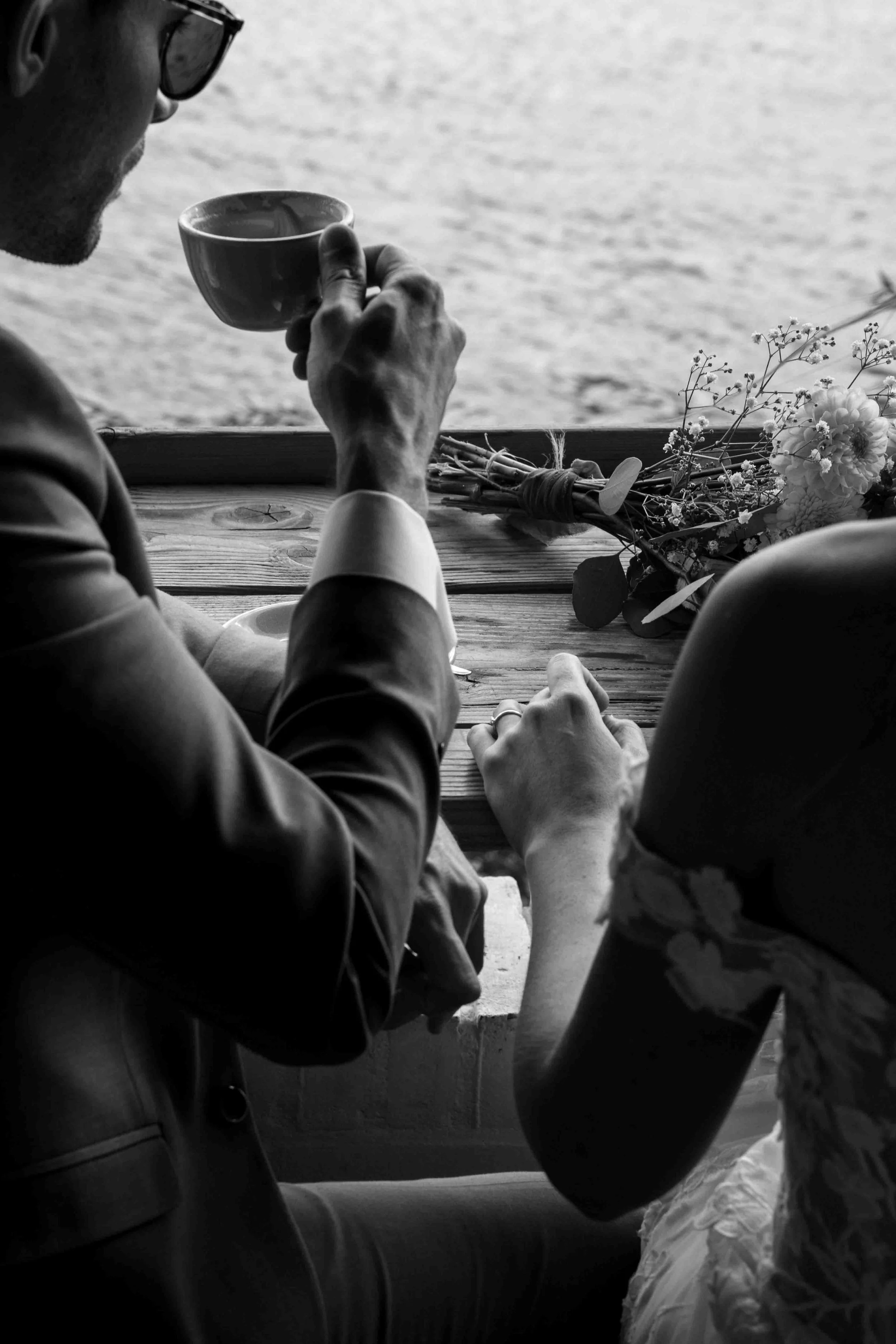 bruidegom drinkt koffie met de bruid langs het water