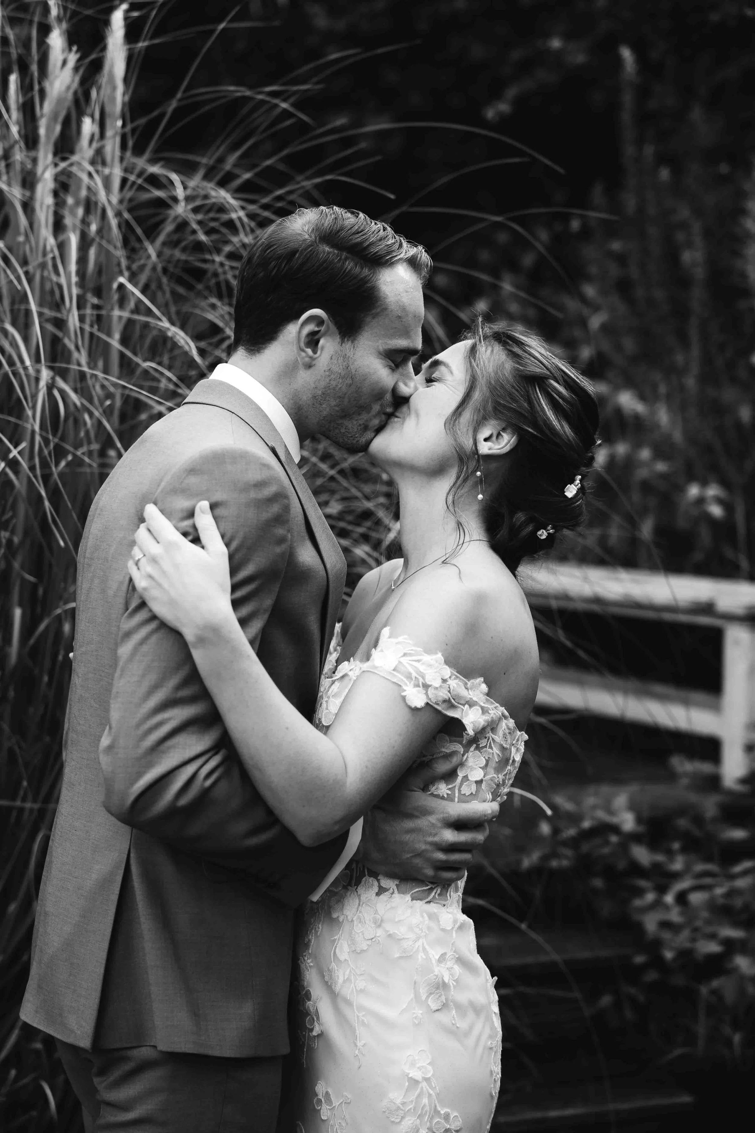 bruidspaar kust elkaar na hun first look voor bruiloft in nijmegen in de zomer