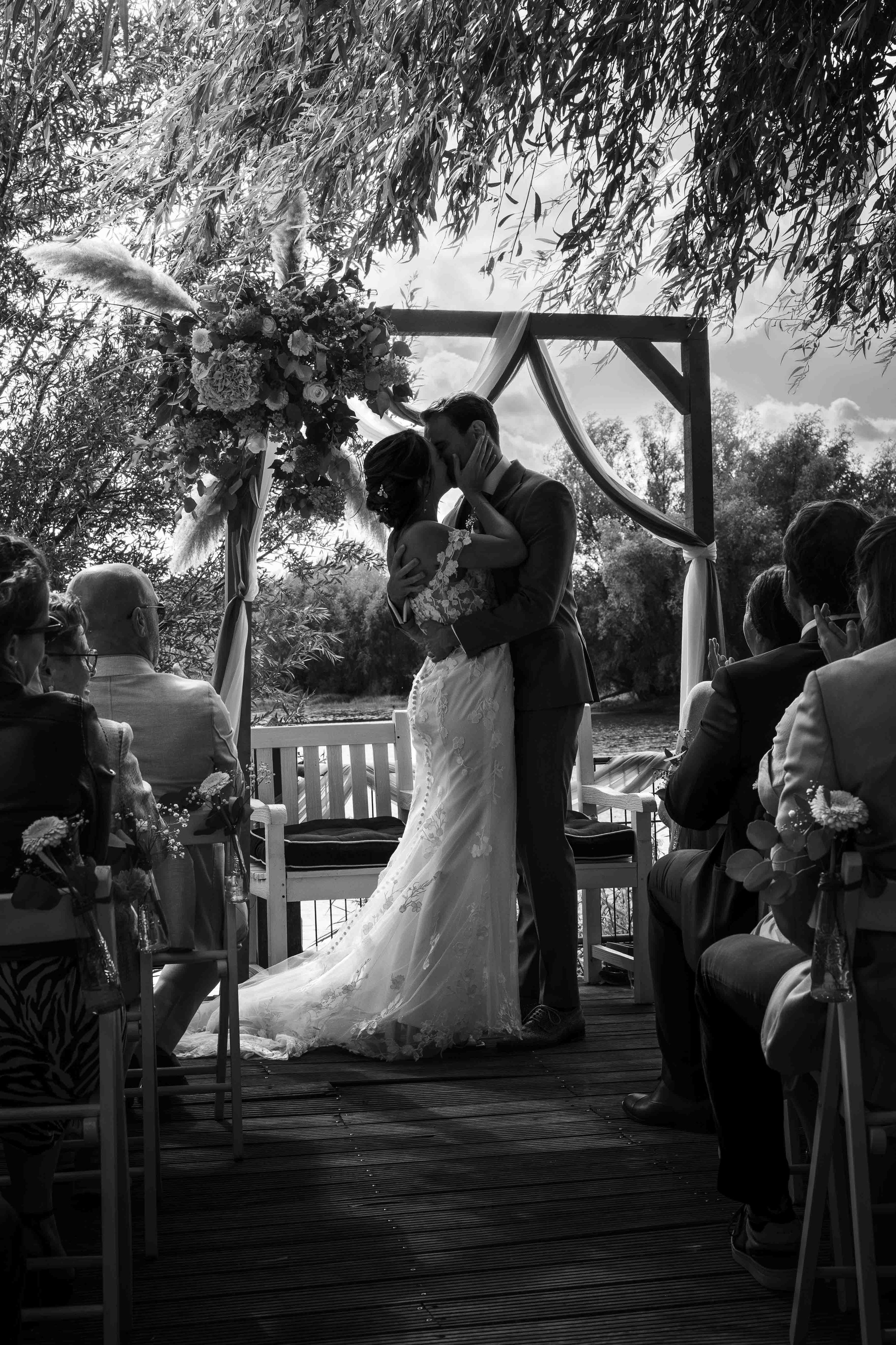 gelukkig bruidspaar in de zomer in nijmegen kust elkaar tijdens de ceremonie