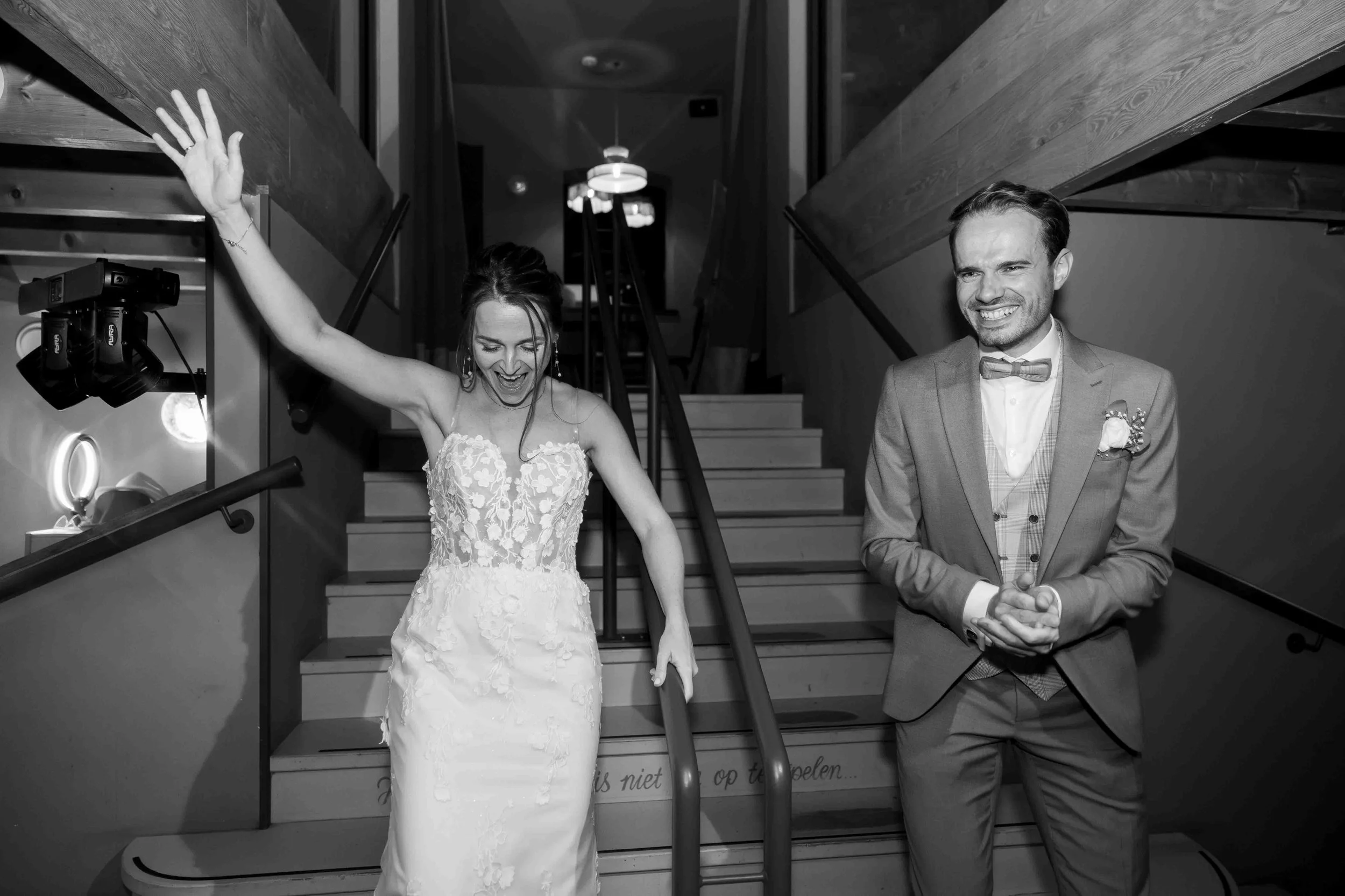 gelukkig bruidspaar in de zomer in nijmegen komen de trap af tijdens een feest