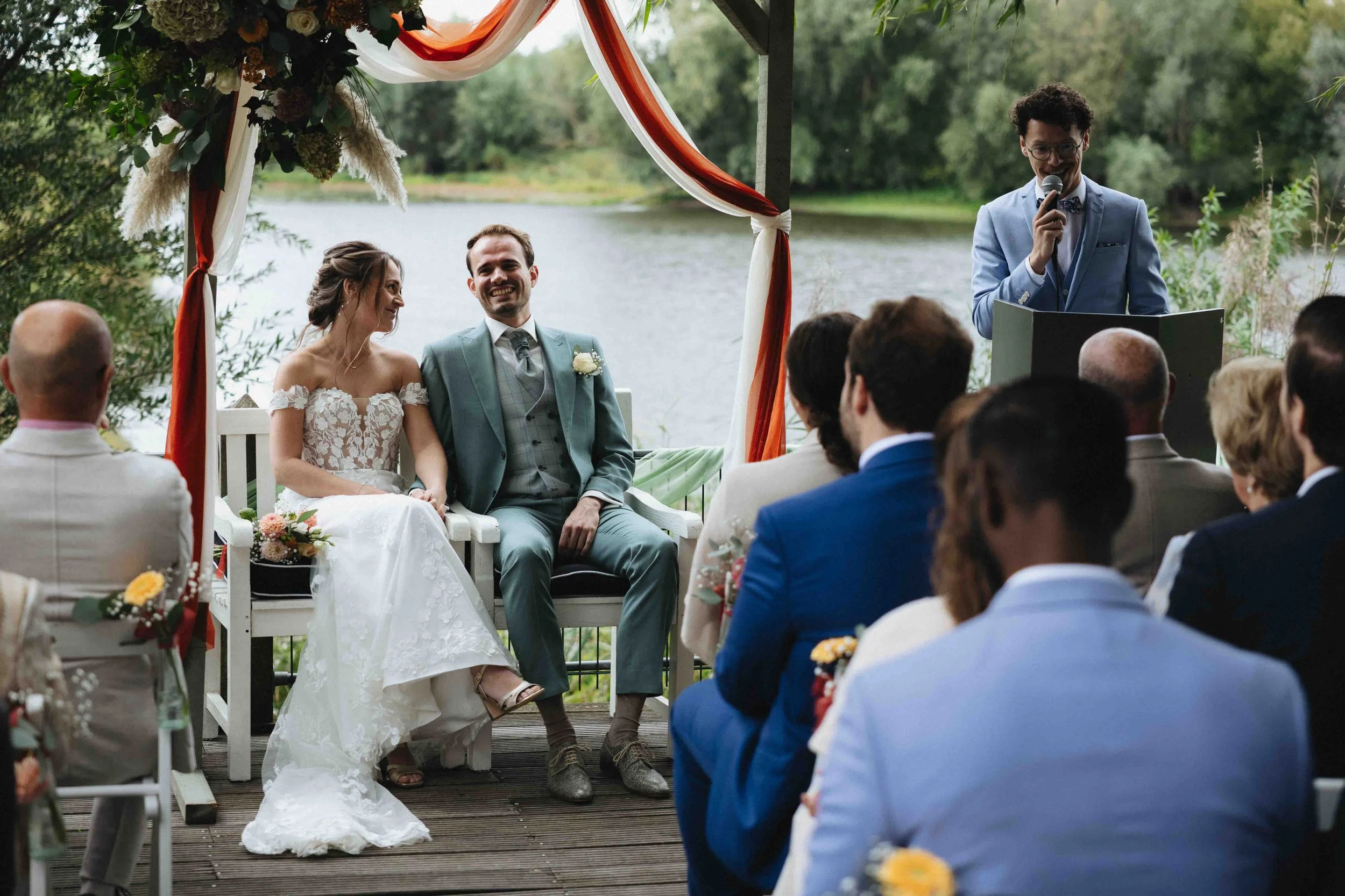 gelukkig bruidspaar in de zomer in nijmegen, lachen tijdens de ceremonie