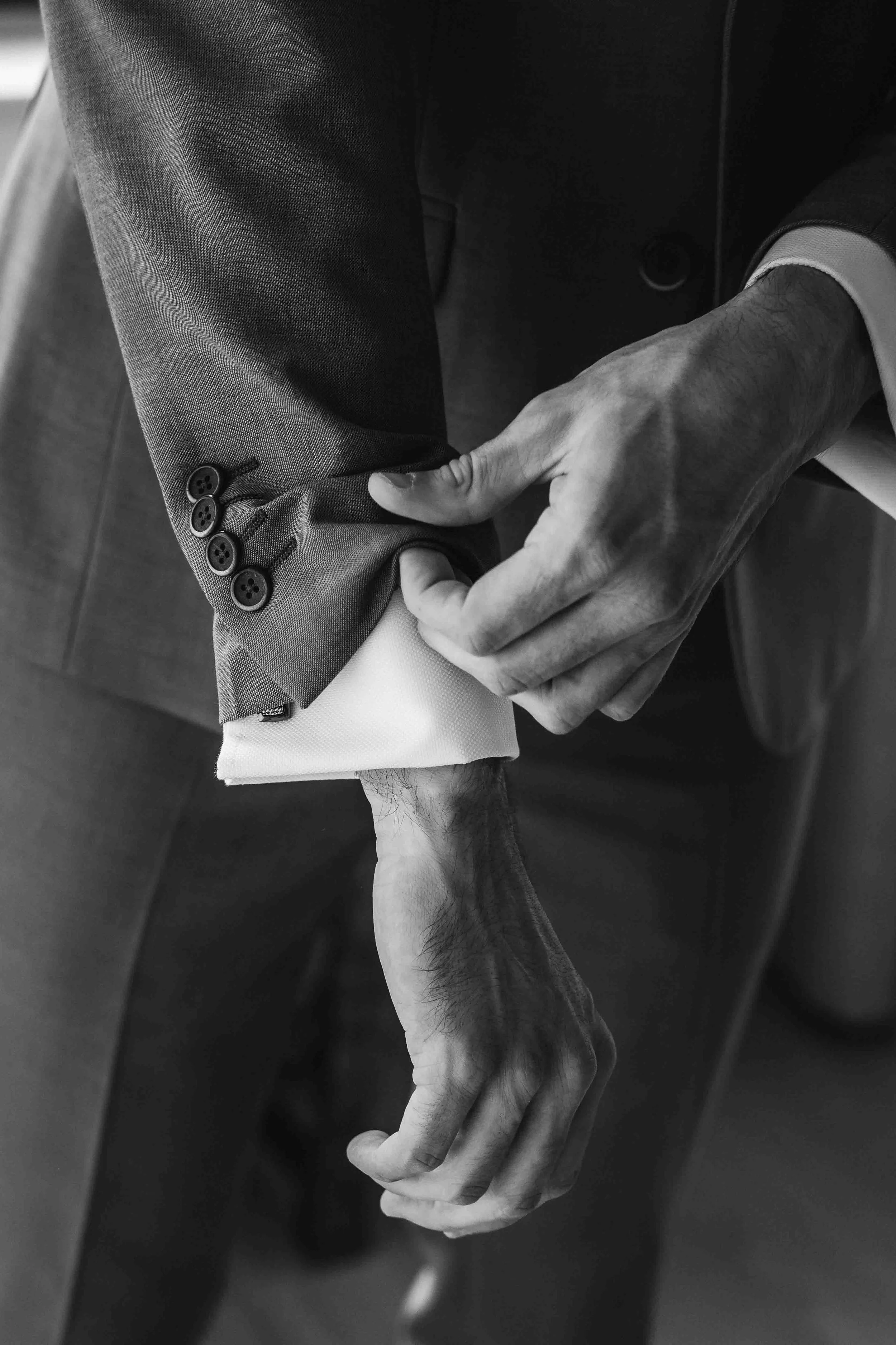bruidegom doet de mouw van zijn pak goed voorafgaand aan de bruiloft