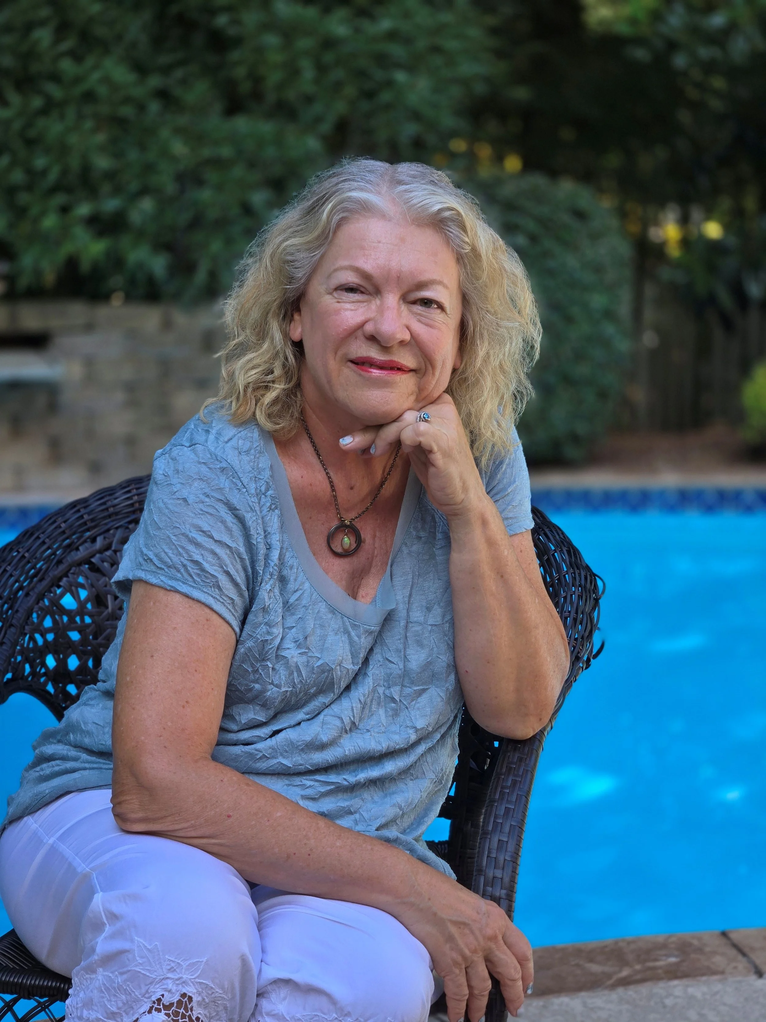Susan smiling facing camera with chin resting on hand