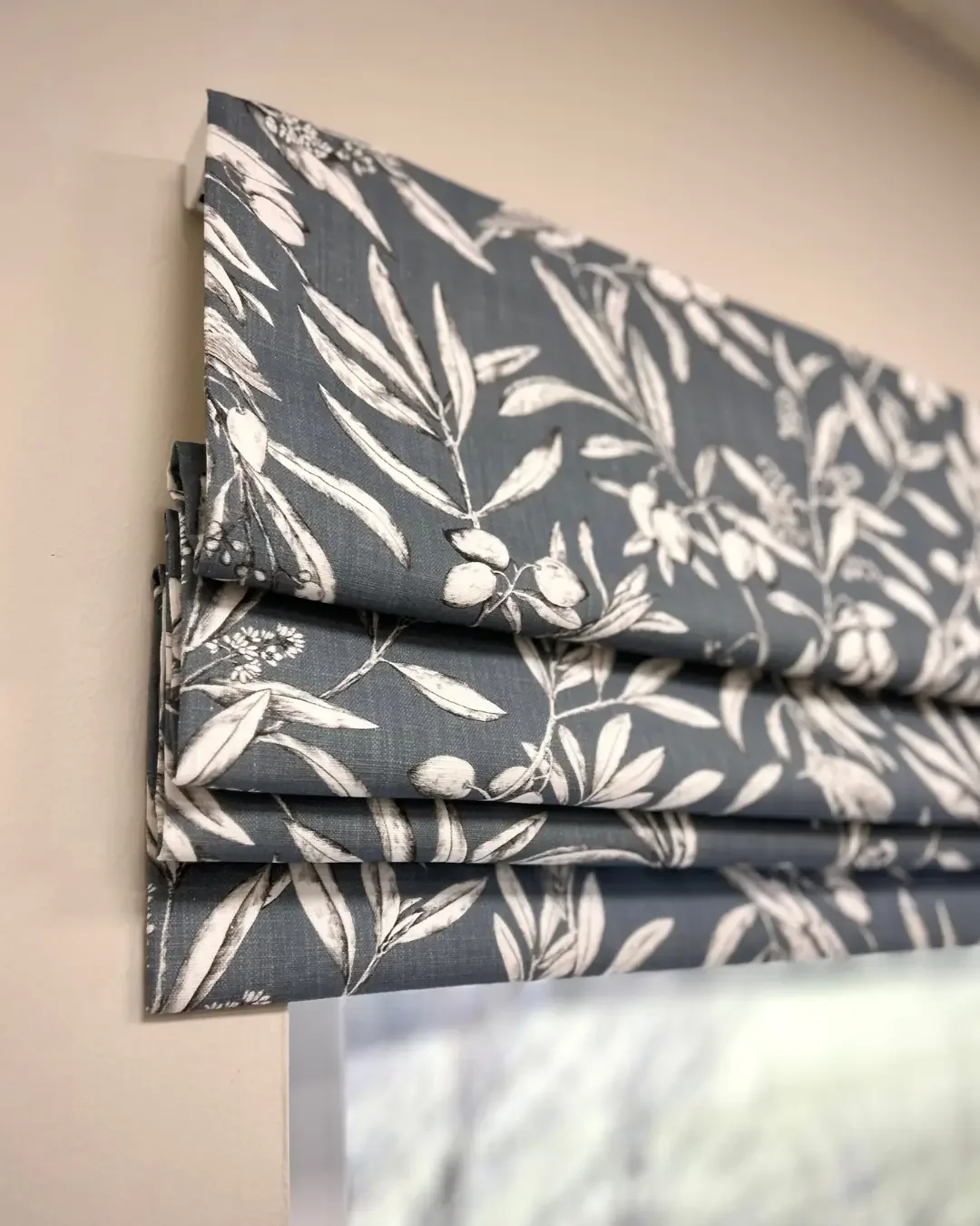 A close up of a handmade roman blind in aviary blue cotton fabric by Prestigious Textiles