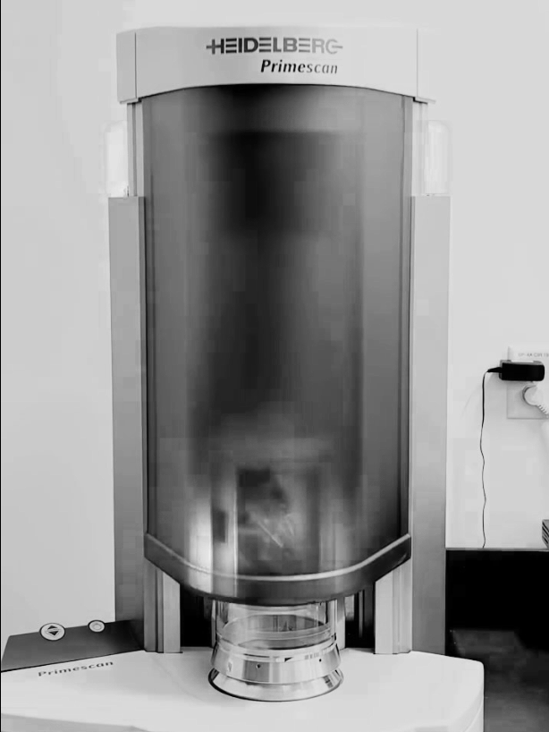 A large medical or laboratory device with the label 'HEIDELBERG Primescan' on top, standing on a table in a clinical setting.