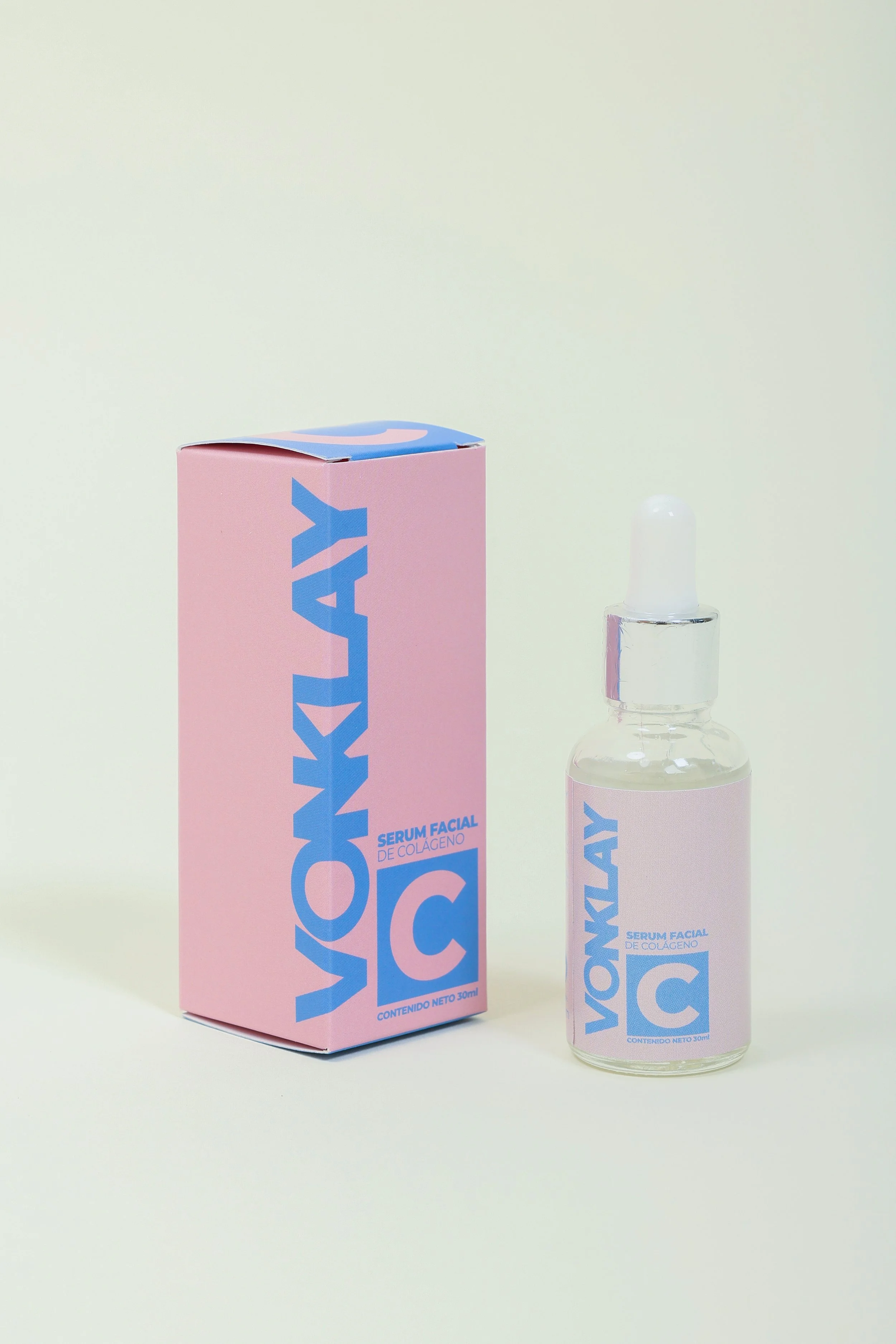 Botella y caja de serum facial de colágeno, en envase de 30 ml, con diseño en colores rosado y azul.