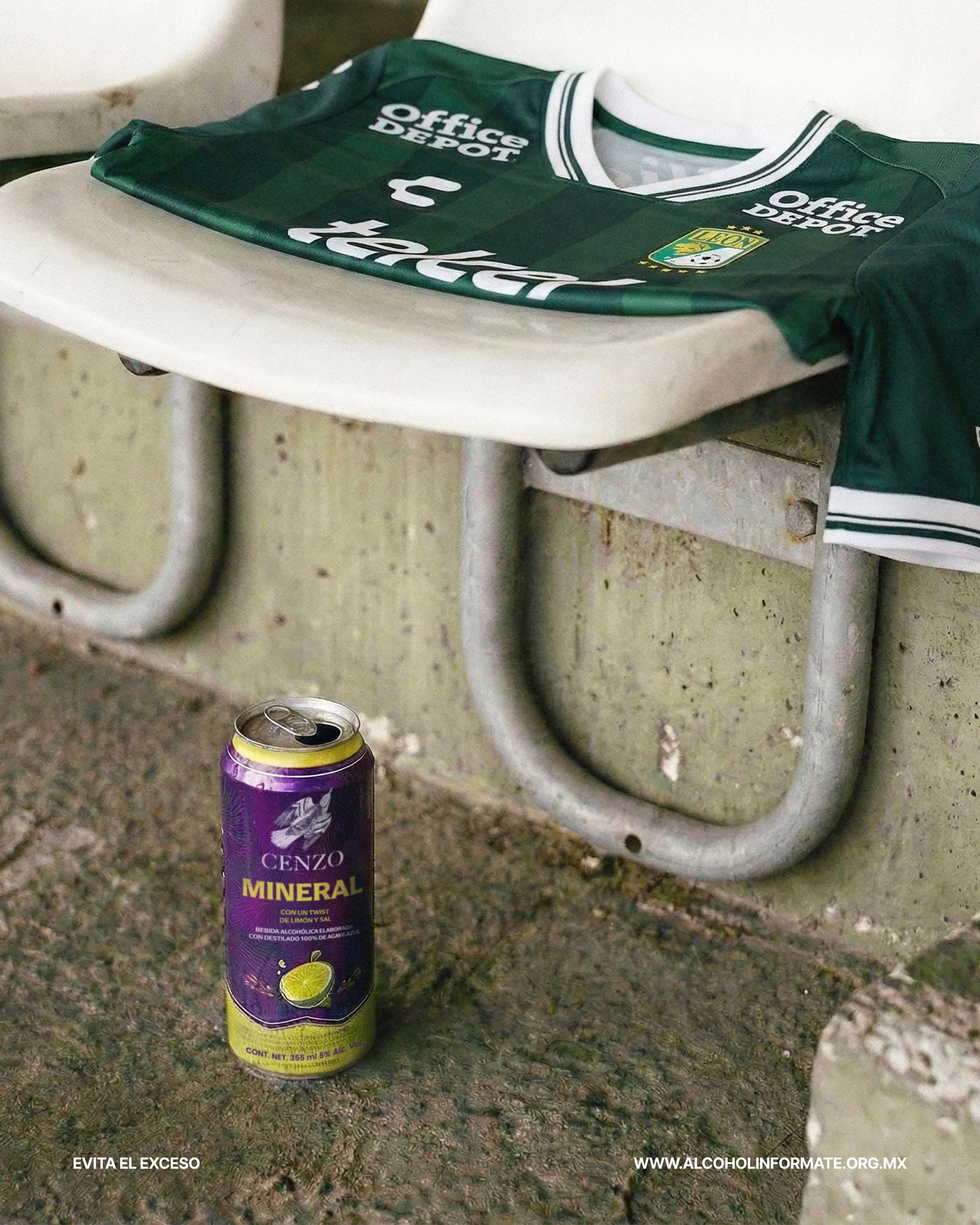 Una camiseta de fútbol en un banco de parque y una lata de refresco mineral en el suelo.