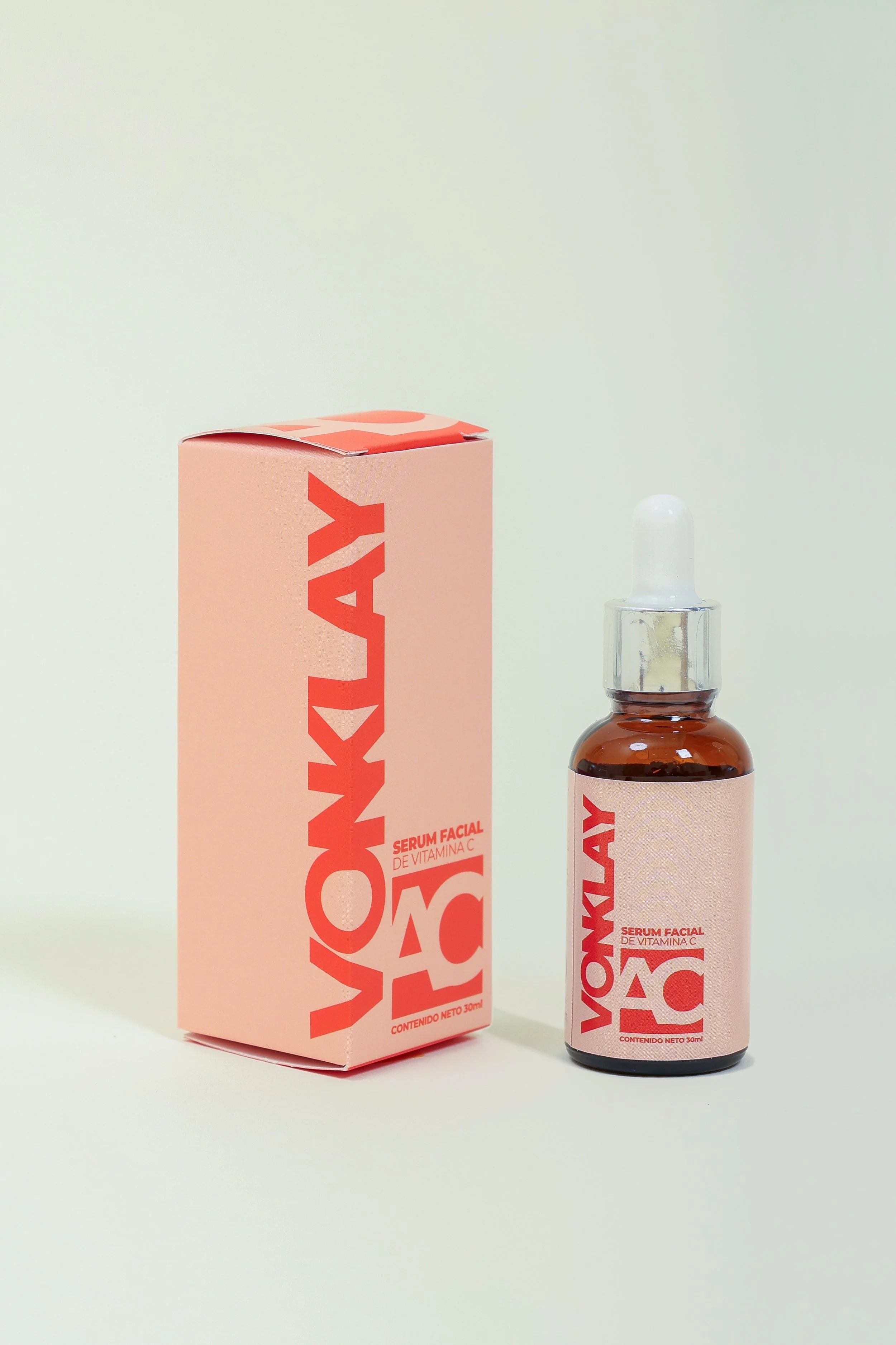 Botella y caja de serum facial de vitamina C de color rosa