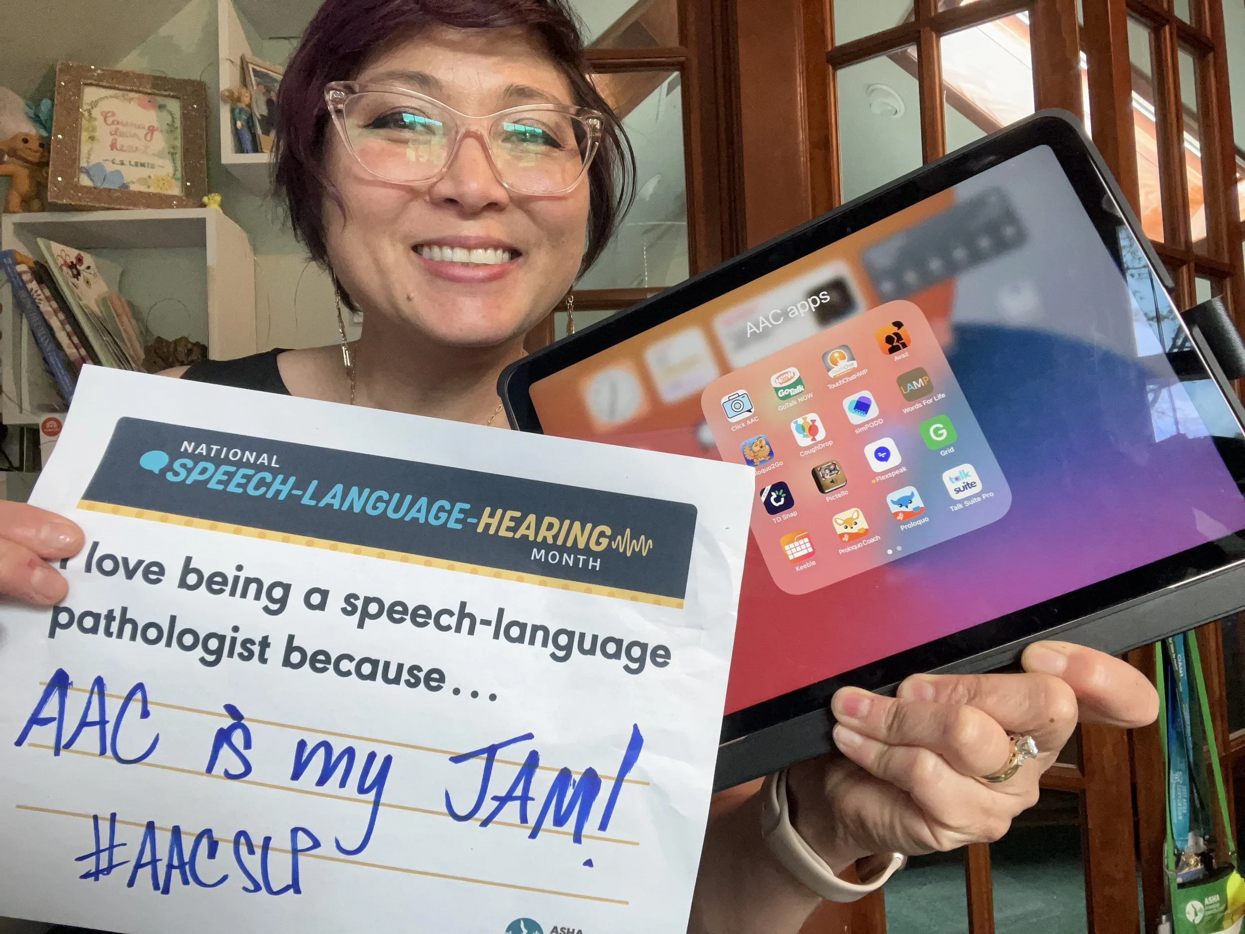 Asian american SLP holding an iPad with communication apps and sign that reads "I love being a speech-language pathologist because AAC is my jam! #AACSLP"