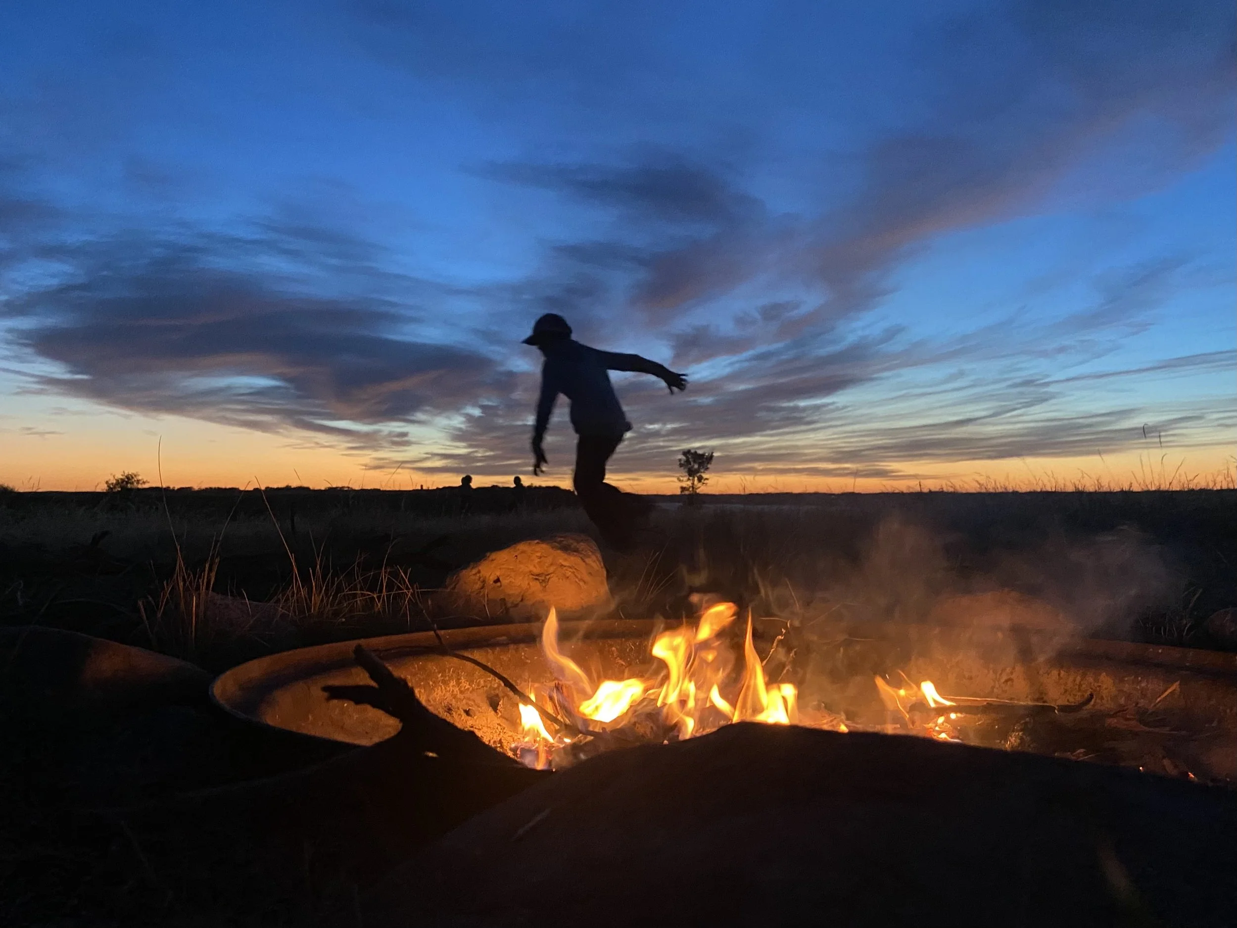 Camper Running Beside a Campfire
