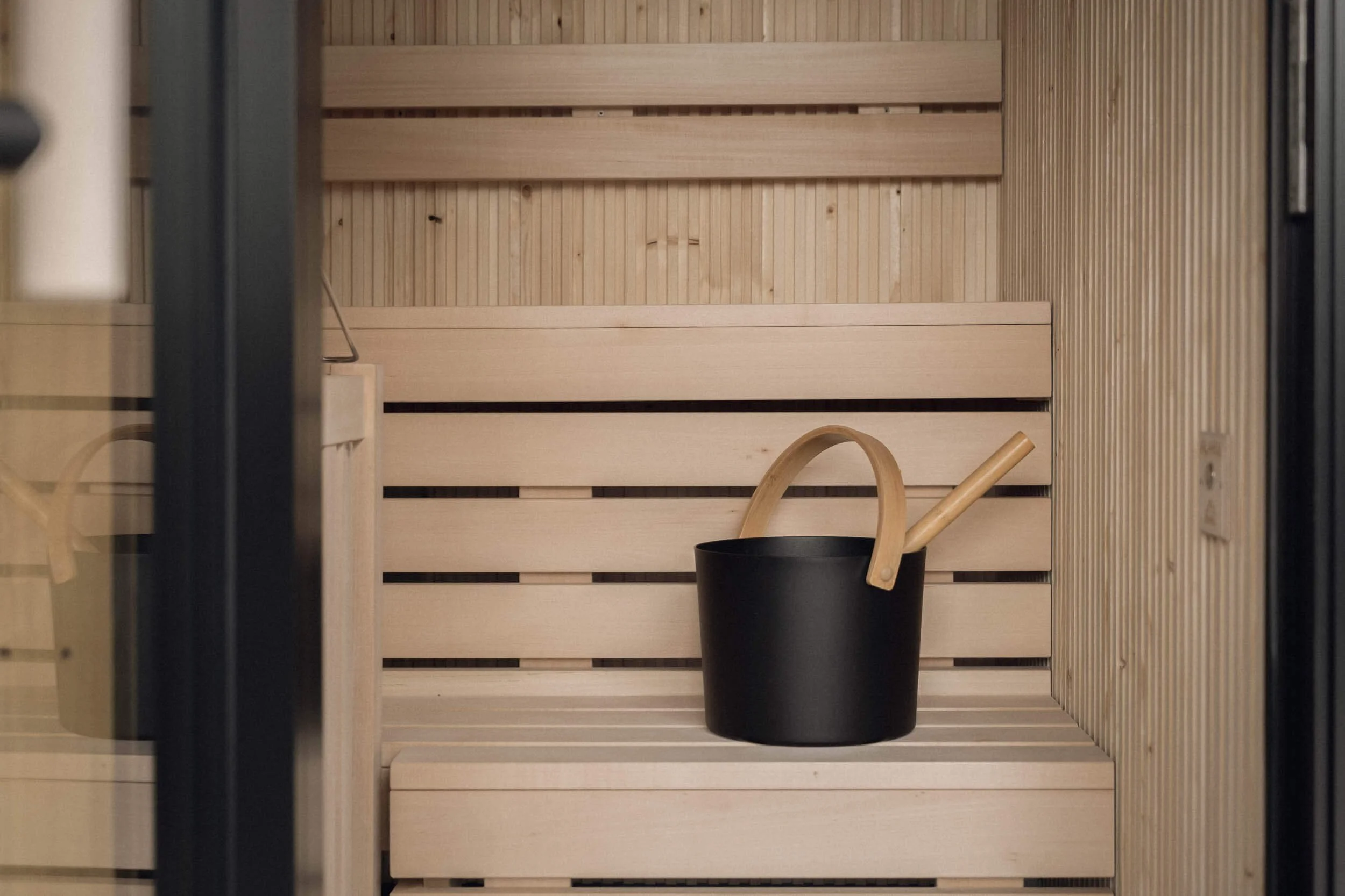 Holzsauna mit handgefertigtem Holztopf und Holzwehrgriffen